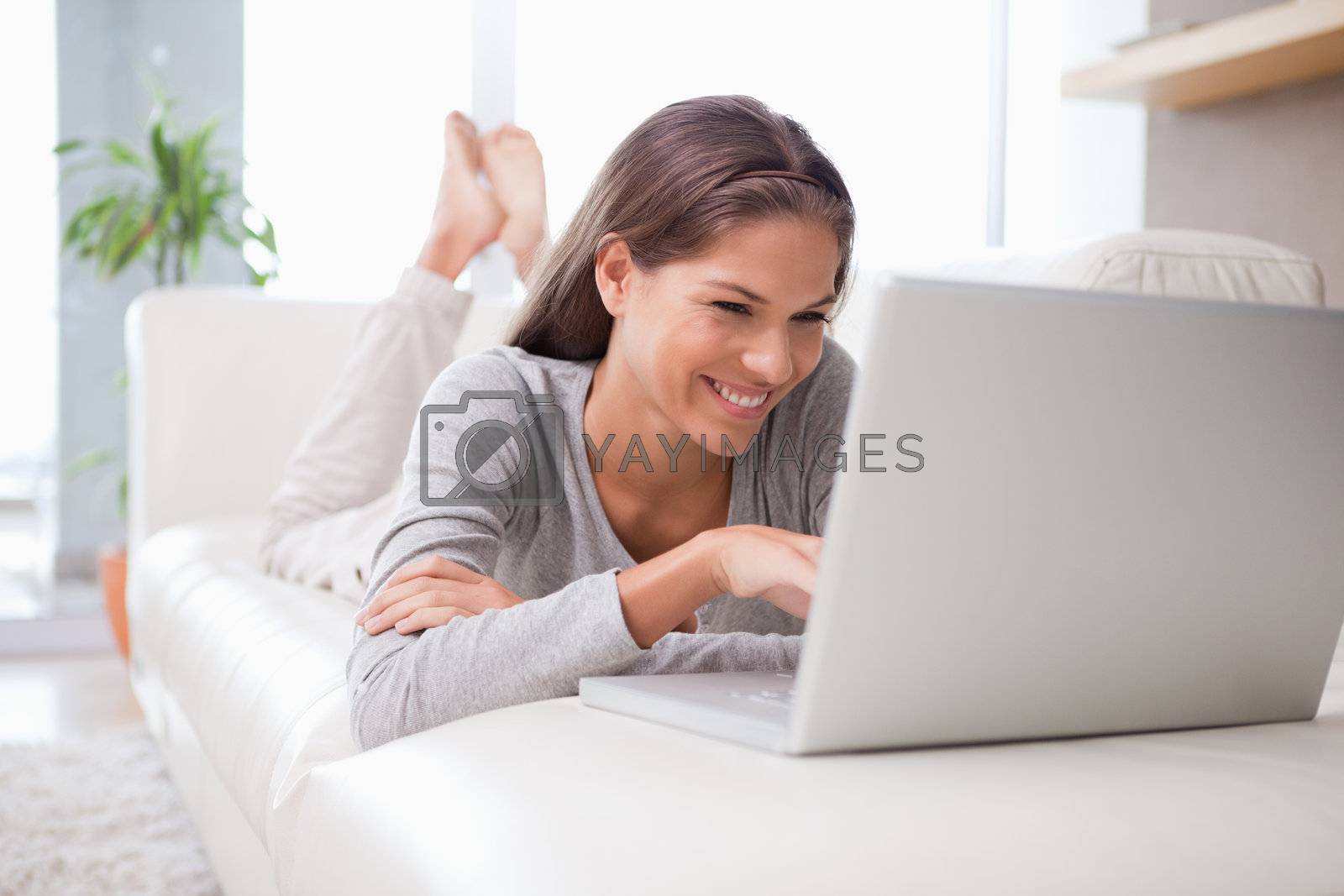 Royalty free image of Woman on the sofa chatting online by Wavebreakmedia