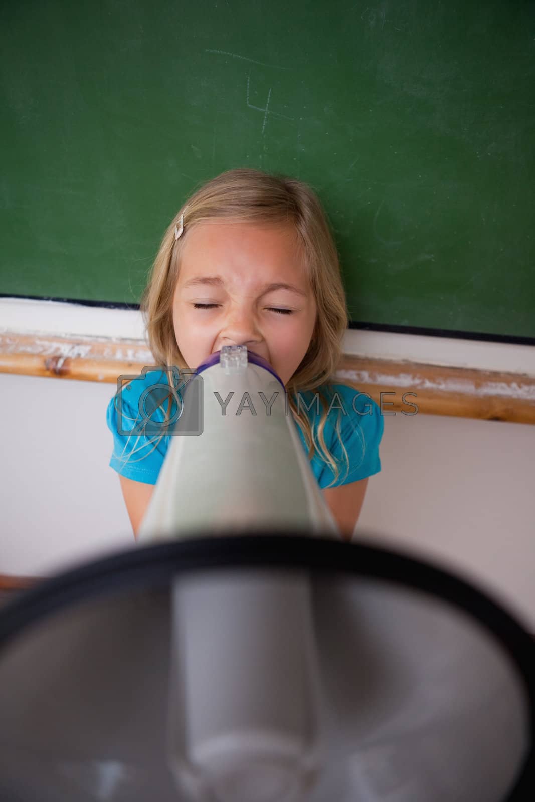 Royalty free image of Portrait of an angry schoolgirl screaming through a megaphone by Wavebreakmedia