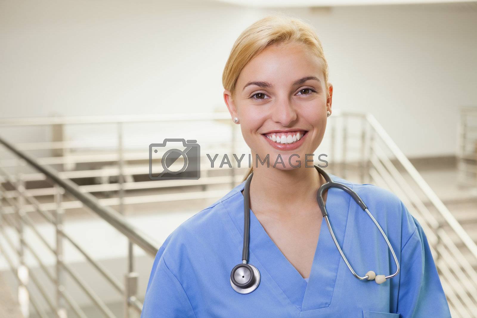 Royalty free image of Nurse in a stairwell smiling by Wavebreakmedia