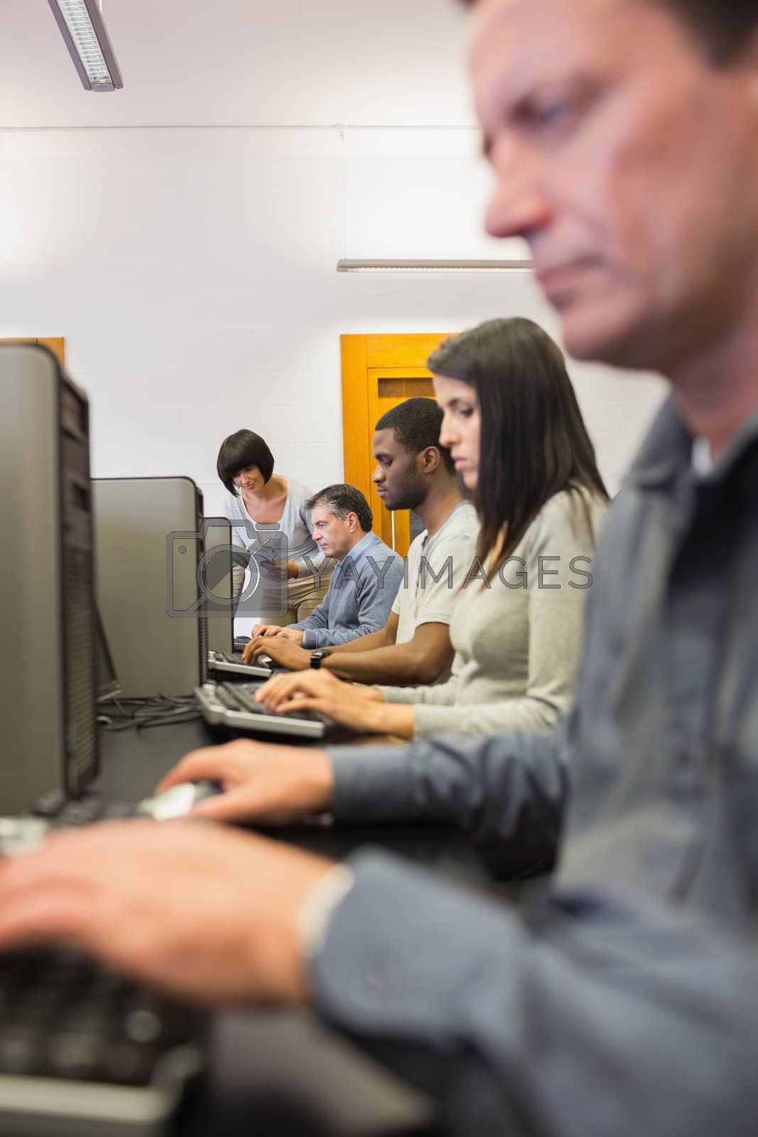 Royalty free image of Woman helping her student with the computer by Wavebreakmedia