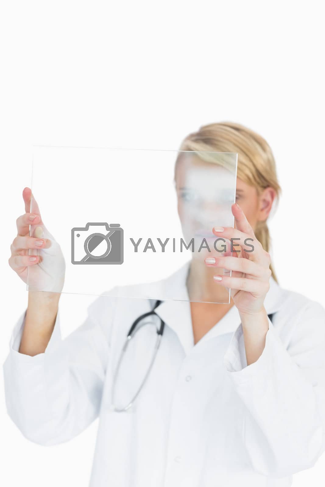 Royalty free image of Doctor studying large blank pane by Wavebreakmedia