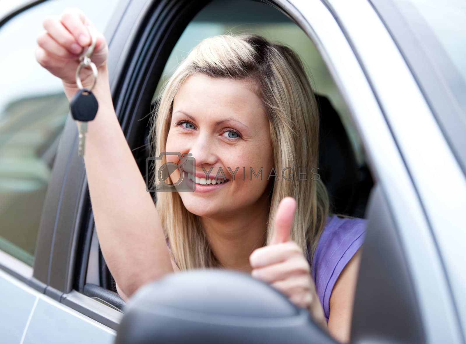 Royalty free image of Lively female driver showing a key after bying a new car  by Wavebreakmedia