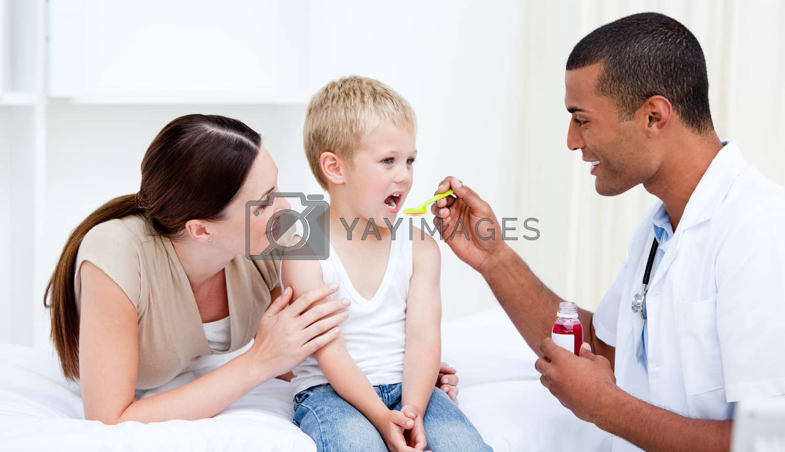 Royalty free image of Mixed-race doctor giving some syrup to the little boy  by Wavebreakmedia