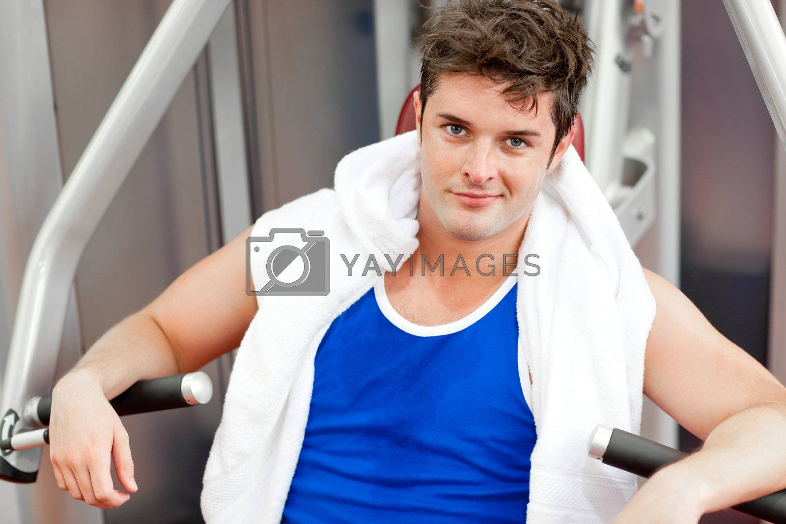 Royalty free image of Confident young man with a towel using a bench press by Wavebreakmedia