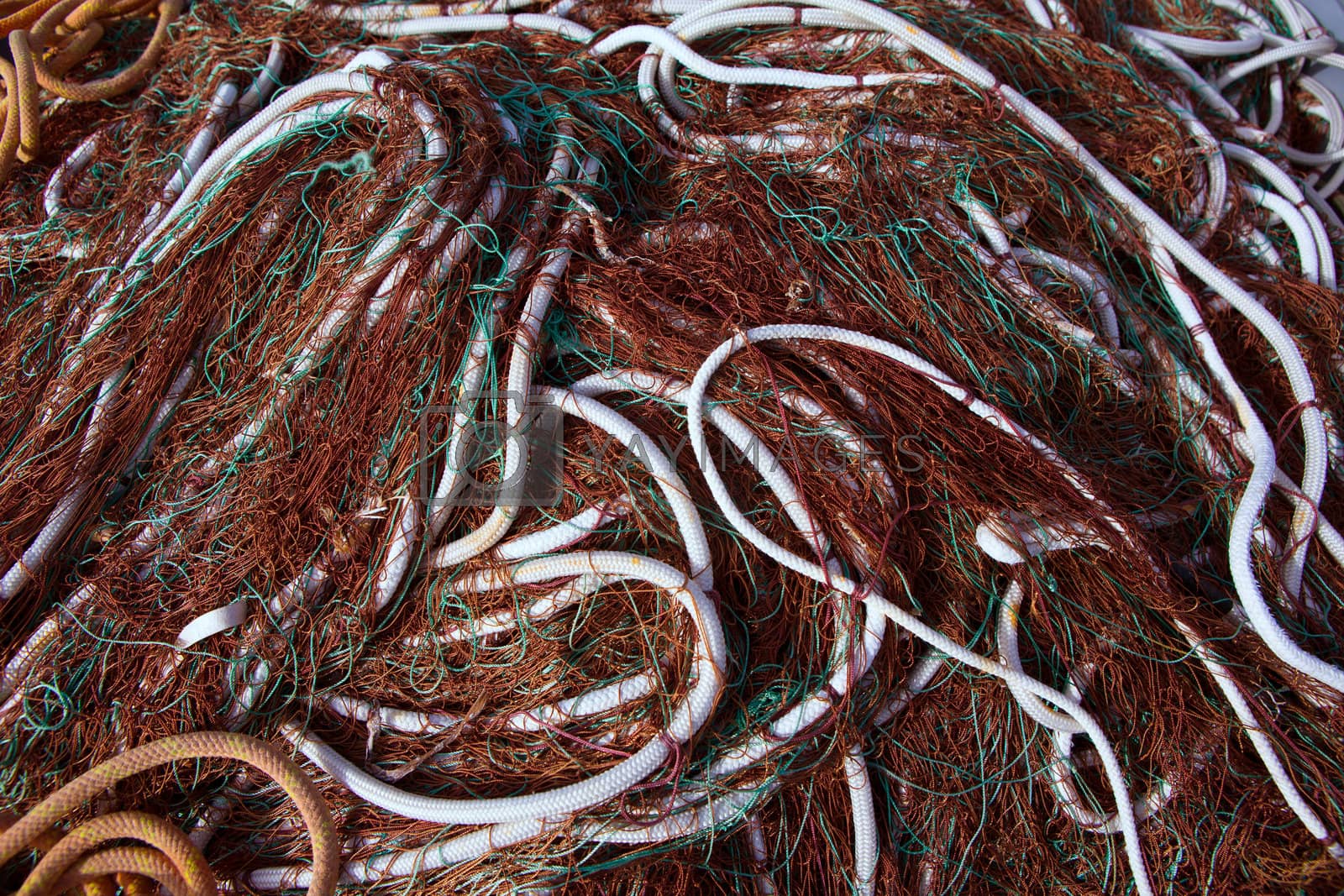 Royalty free image of fishing nets pattern mess stacked at port by lunamarina