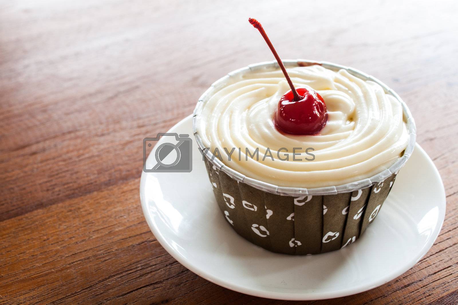 Royalty free image of Cupcake with red cherry on white plate by punsayaporn