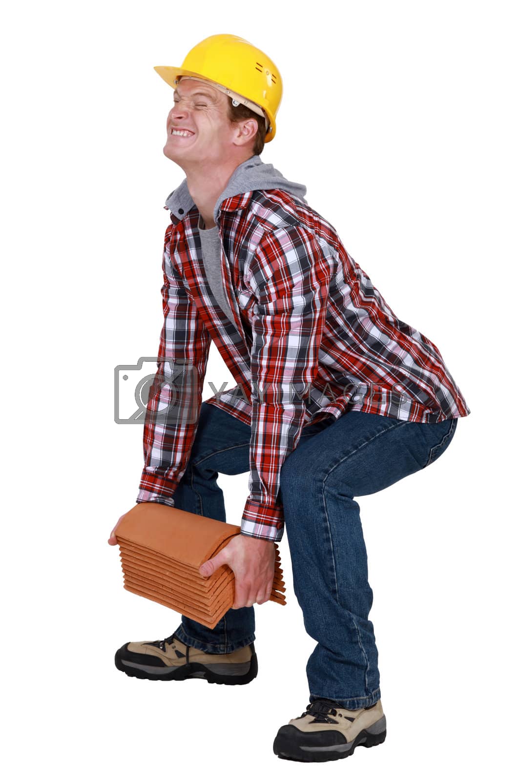 Royalty free image of Tradesman lifting a heavy load by phovoir