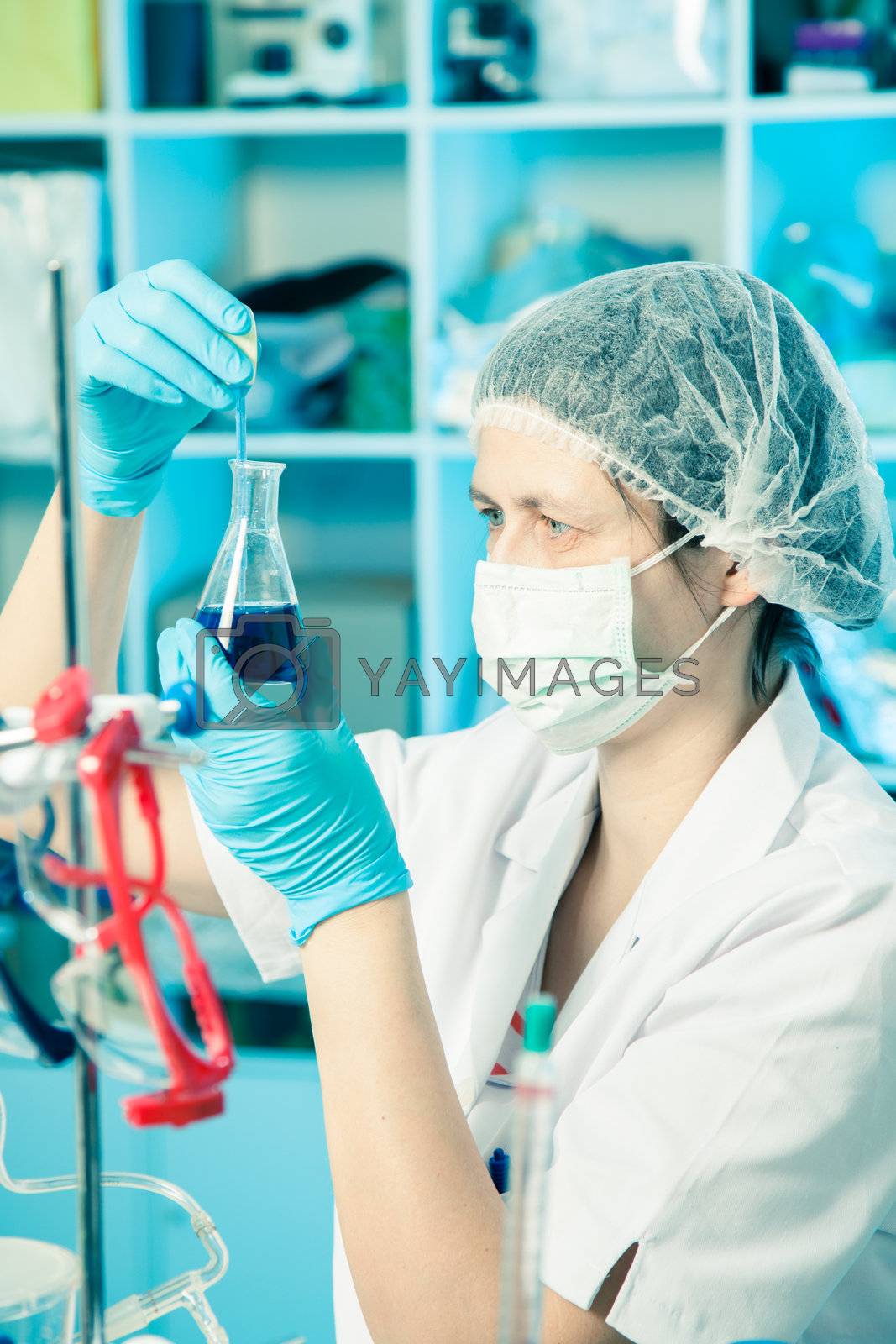 Royalty free image of Scientific researcher holding at a liquid solution in a lab by motorolka