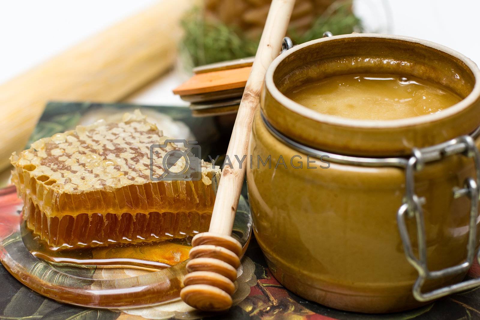 Royalty free image of Honey in pot, honeycomb and stick by lusjen_n