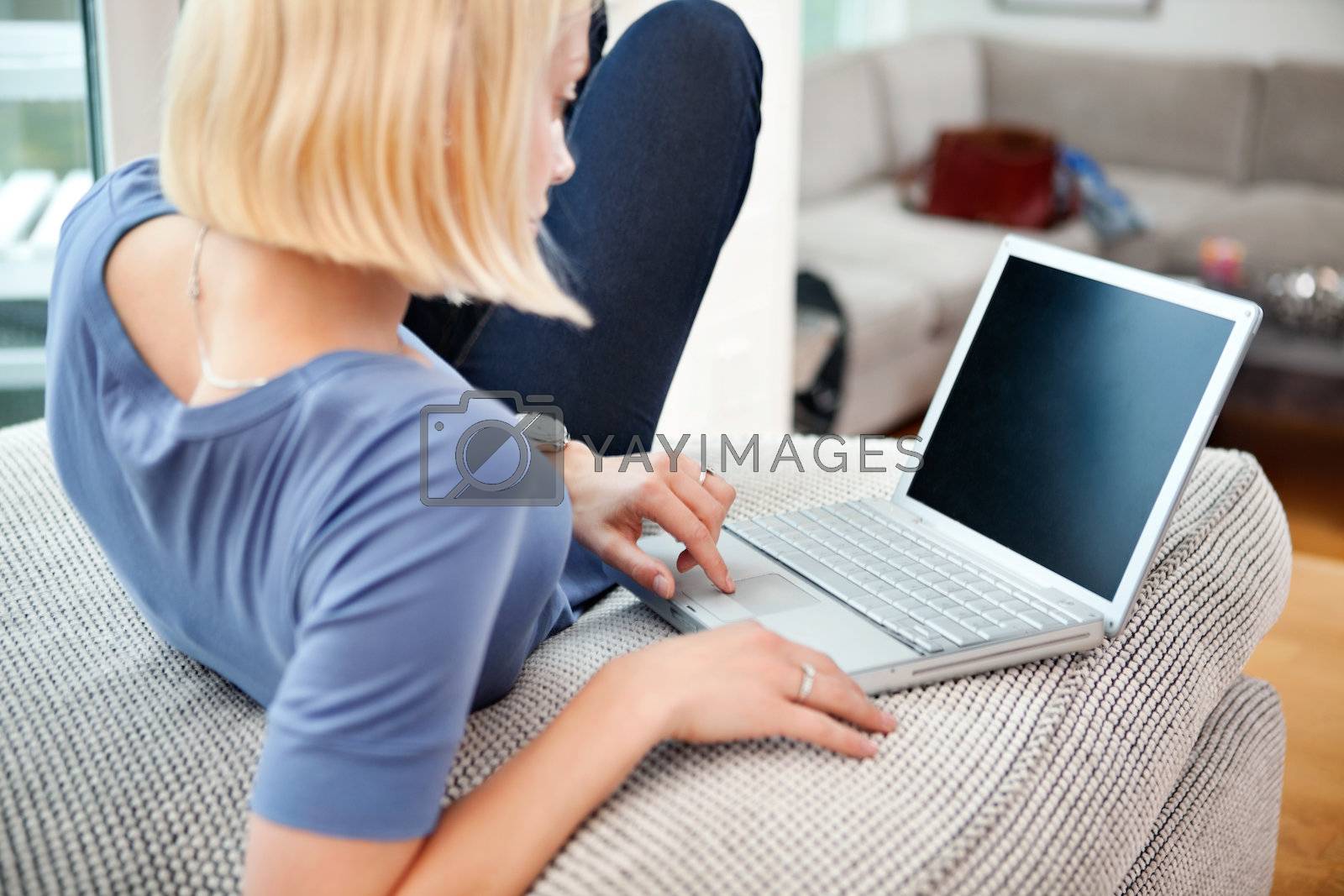Royalty free image of Blond woman with laptop by leaf