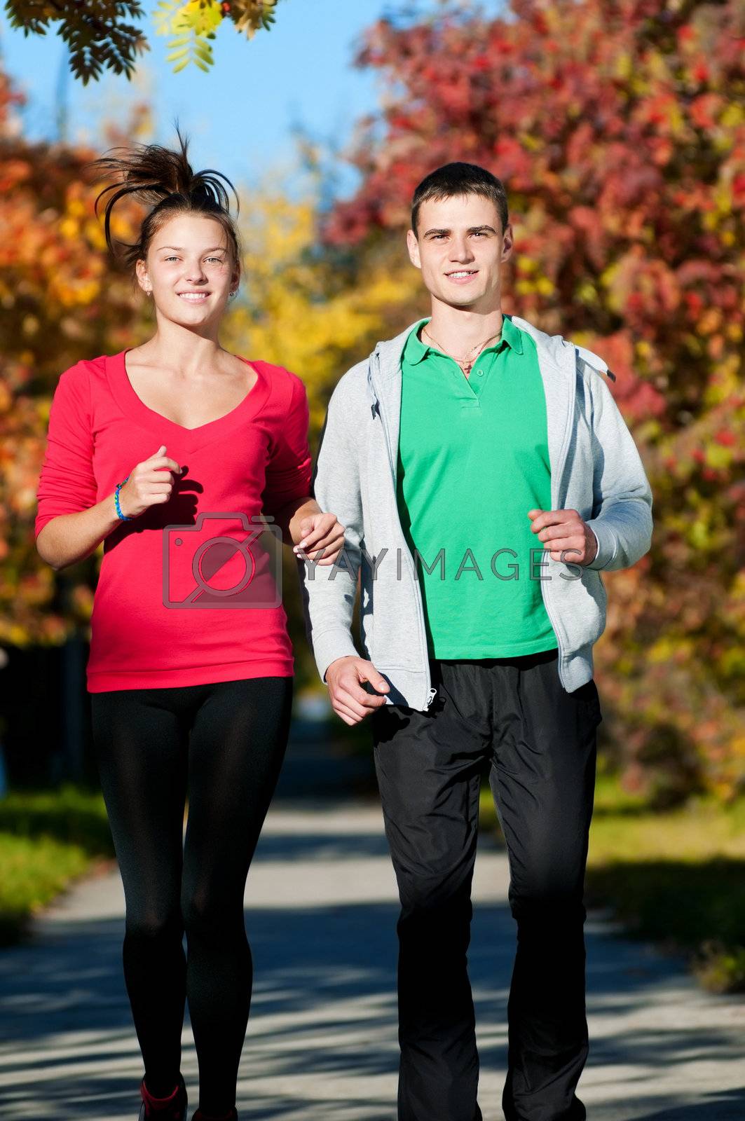 Royalty free image of Young man and woman jogiing by markin