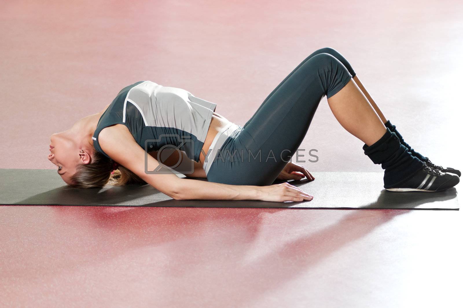 Royalty free image of Woman doing stretching fitness exercise at sport gym. Yoga by markin