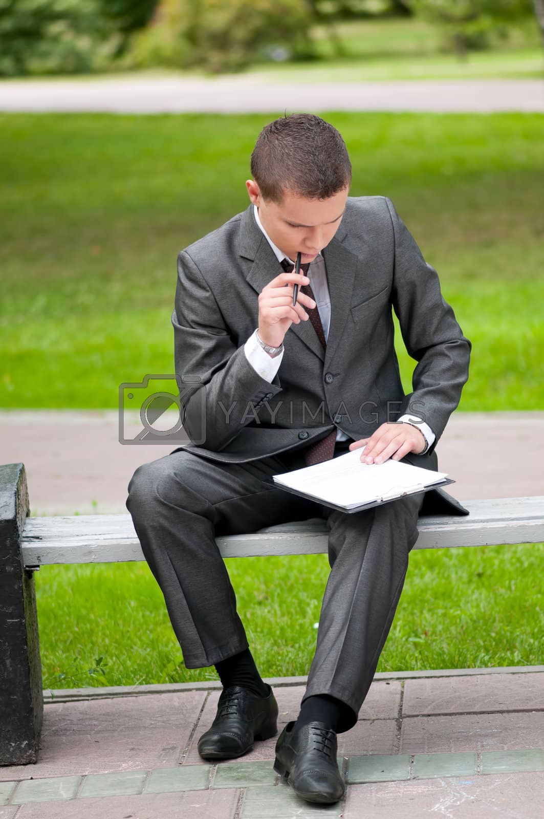 Royalty free image of business man working with papers at park. Student by markin
