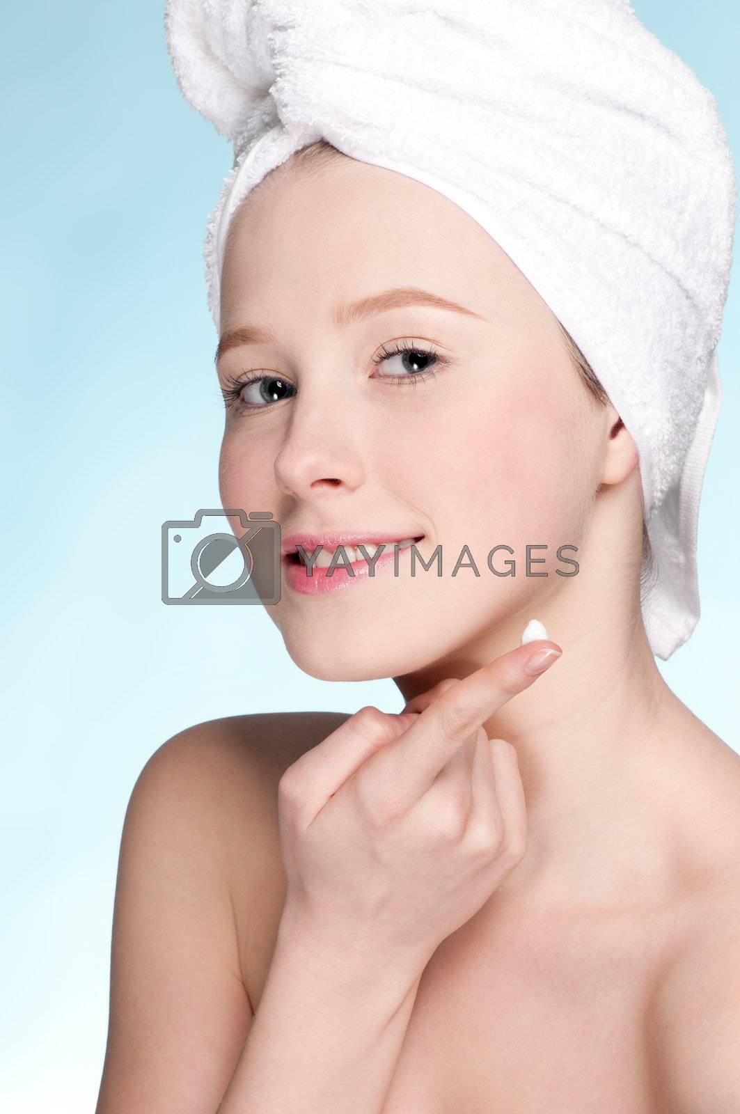 Royalty free image of Beautiful woman applying moisturizer cream on face by markin
