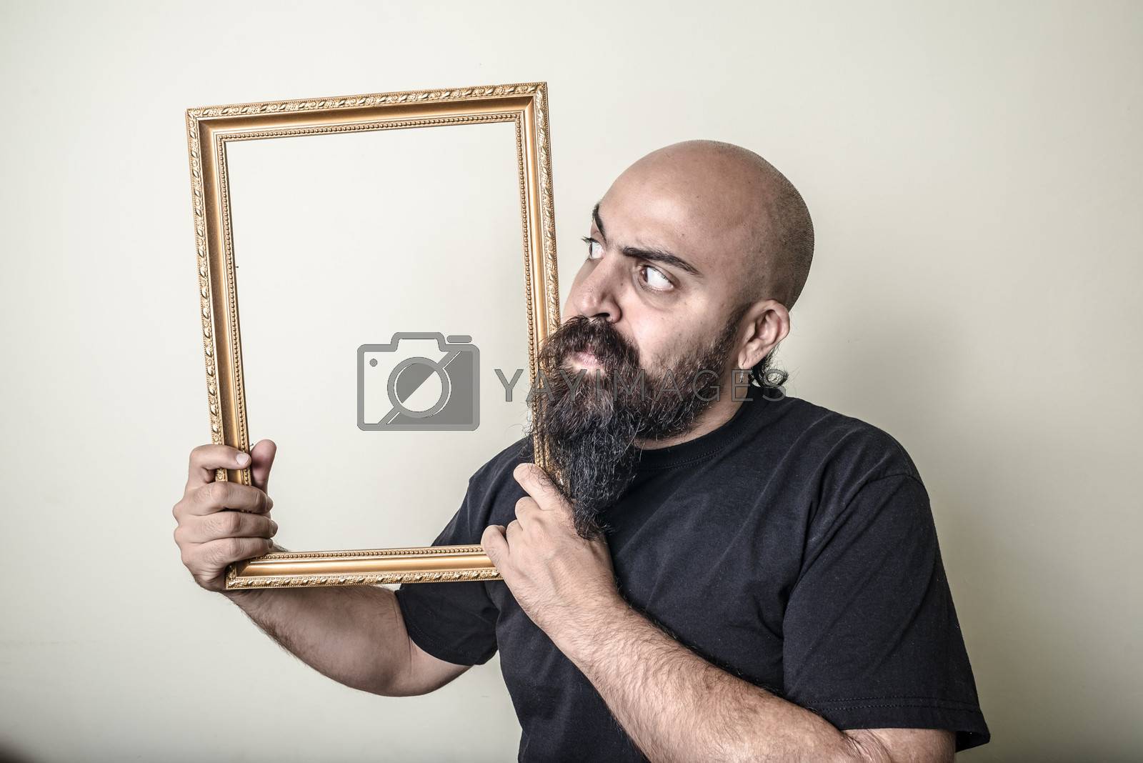 Royalty free image of funny bearded man with golden frame by peus