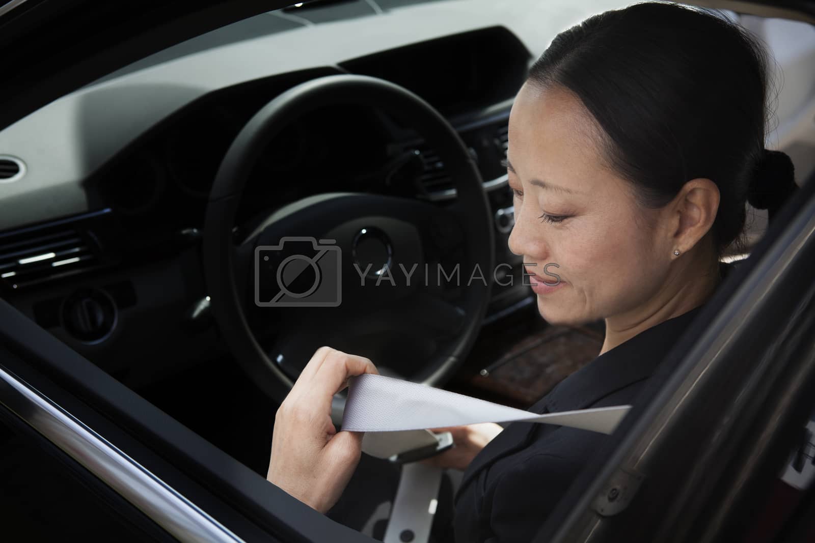 Royalty free image of Mature businesswomen in car fastening seatbelt. by XiXinXing