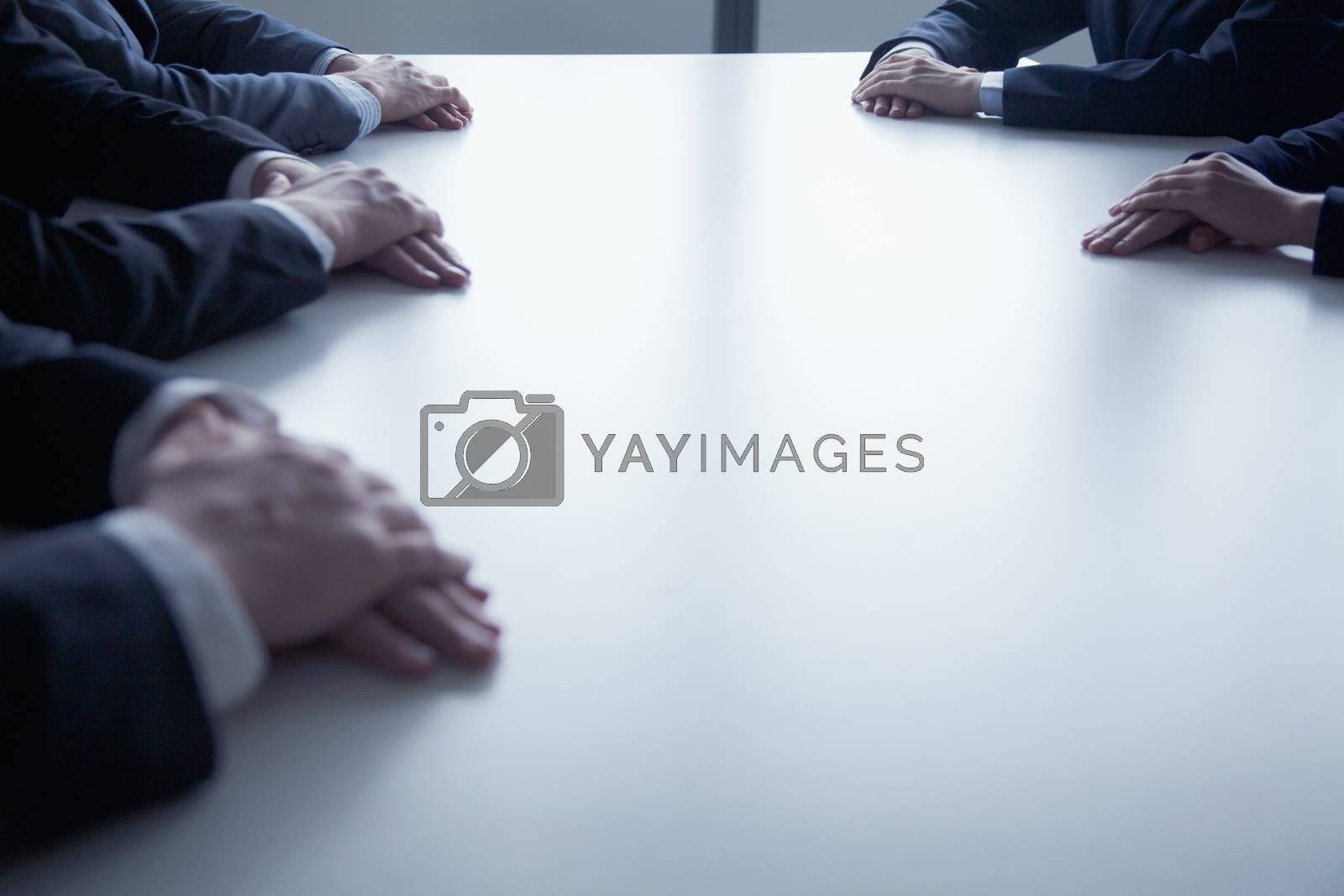 Royalty free image of Close-up on folded hands of business people at the table during a business meeting by XiXinXing