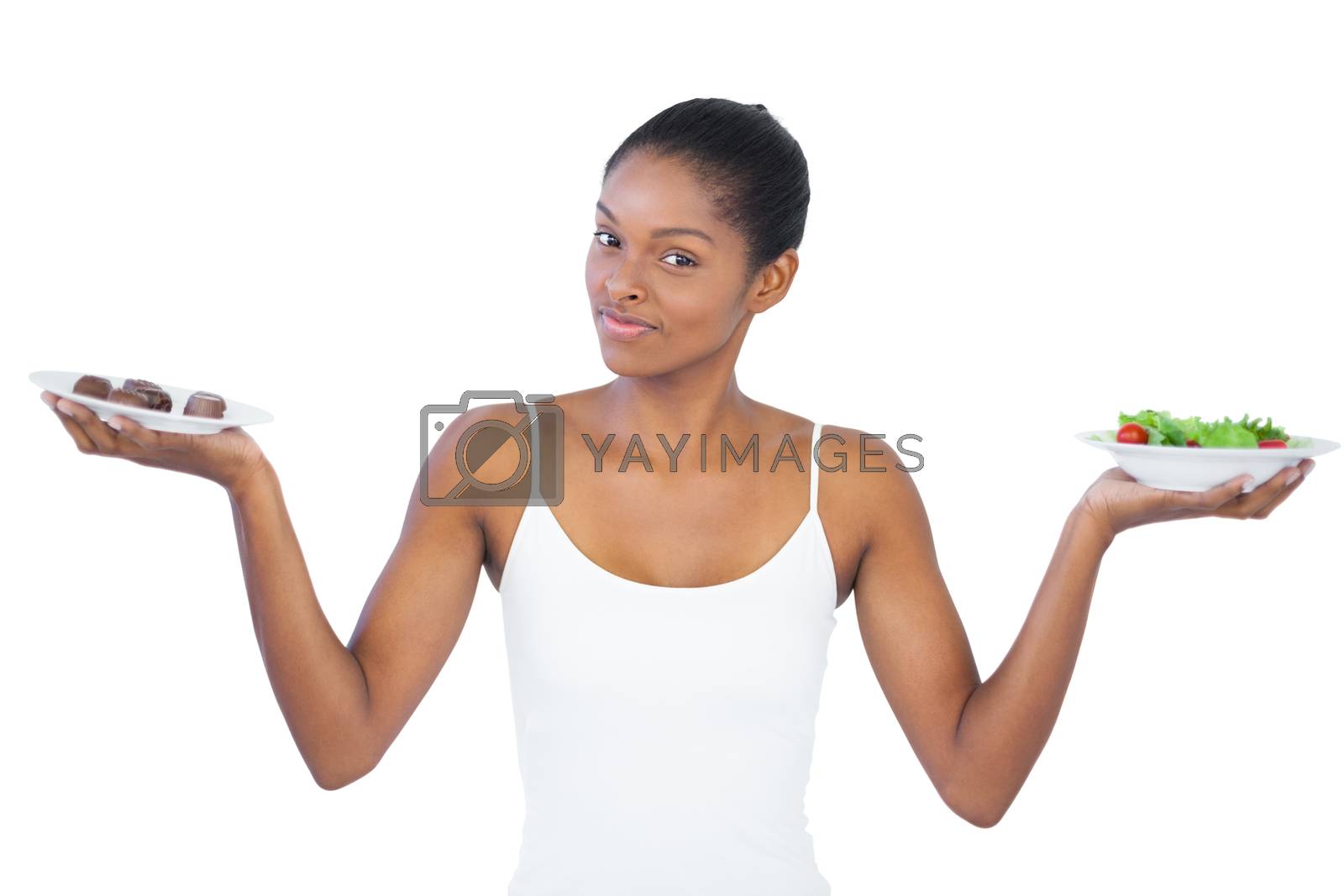 Royalty free image of Pretty woman deciding to eat healthily or not by Wavebreakmedia