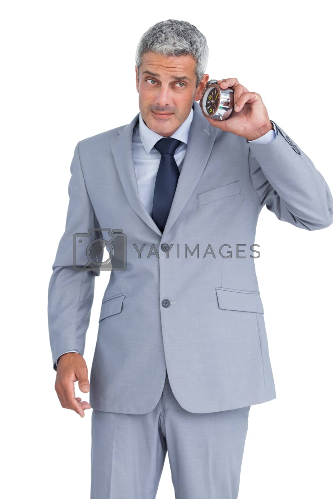 Royalty free image of Concerned businessman with alarm clock  by Wavebreakmedia