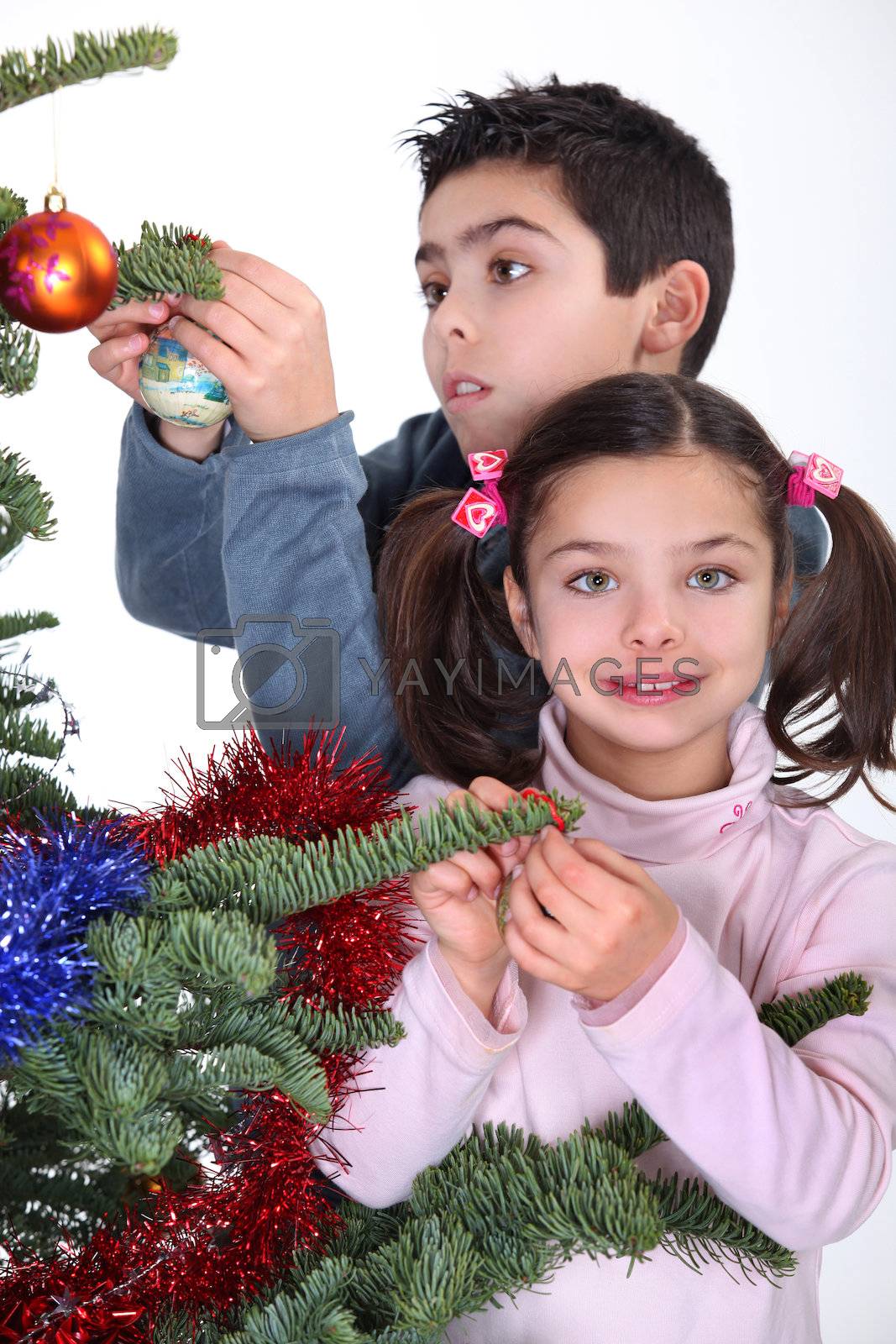 Royalty free image of children decorating Christmas tree by phovoir
