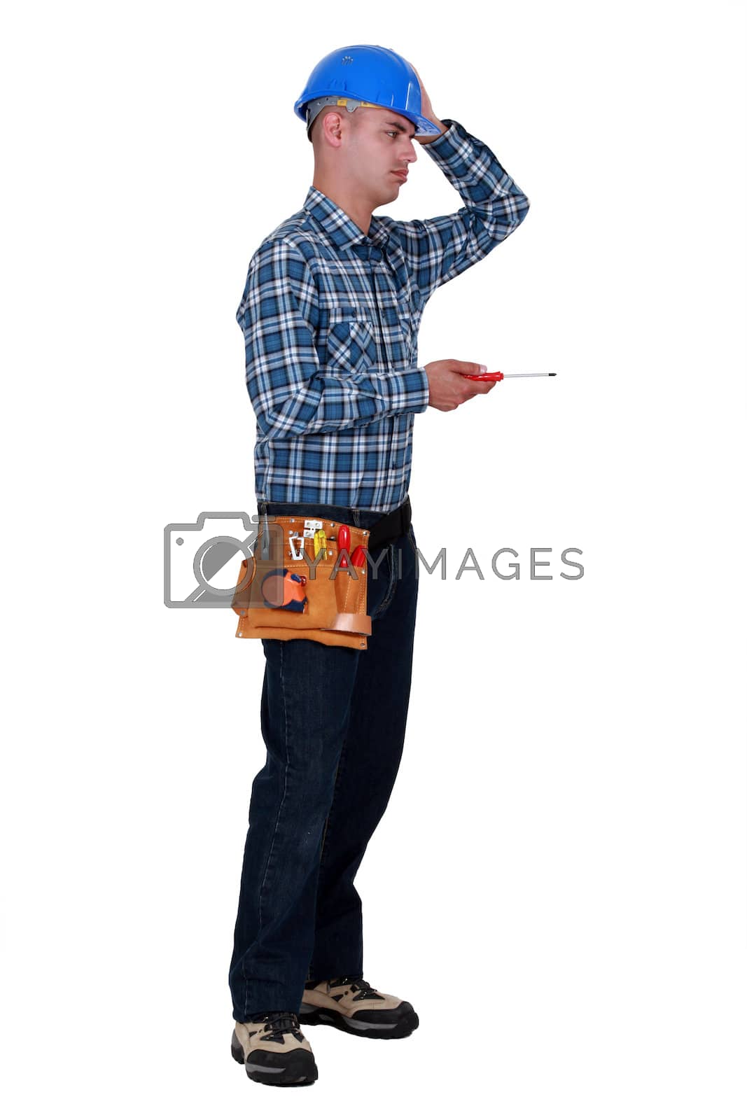 Royalty free image of Annoyed tradesman performing a tedious task by phovoir