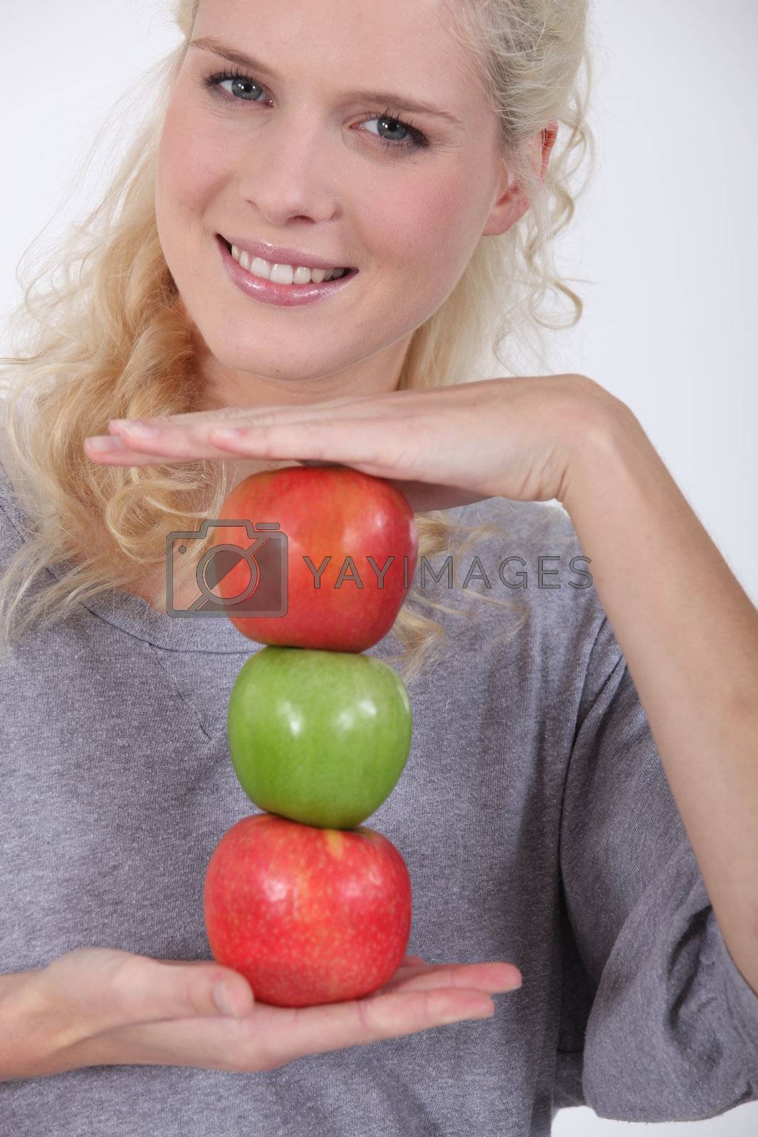 Royalty free image of Woman holding a stack of apples by phovoir