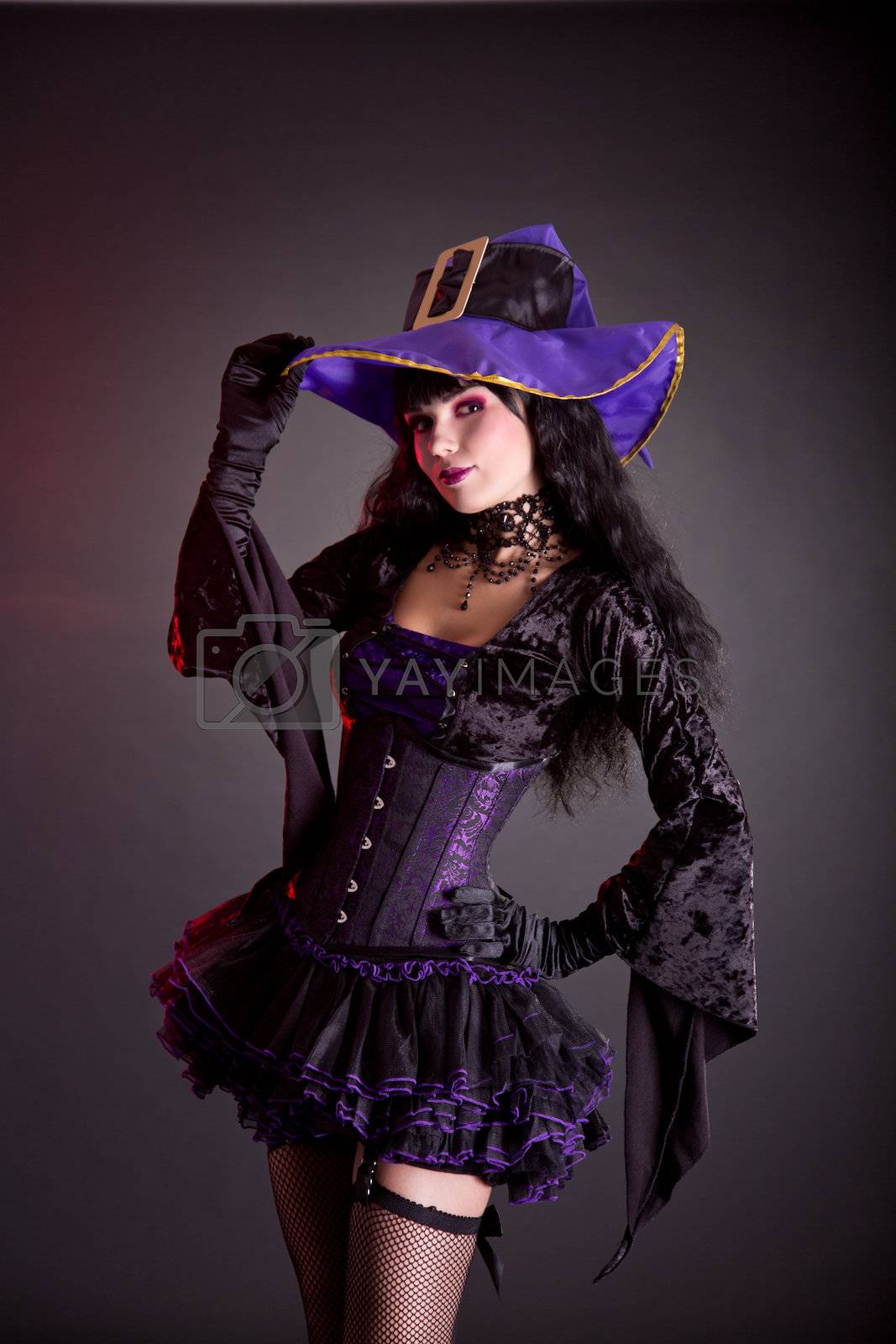 Royalty free image of Cheerful witch in purple and black gothic Halloween costume   by Elisanth