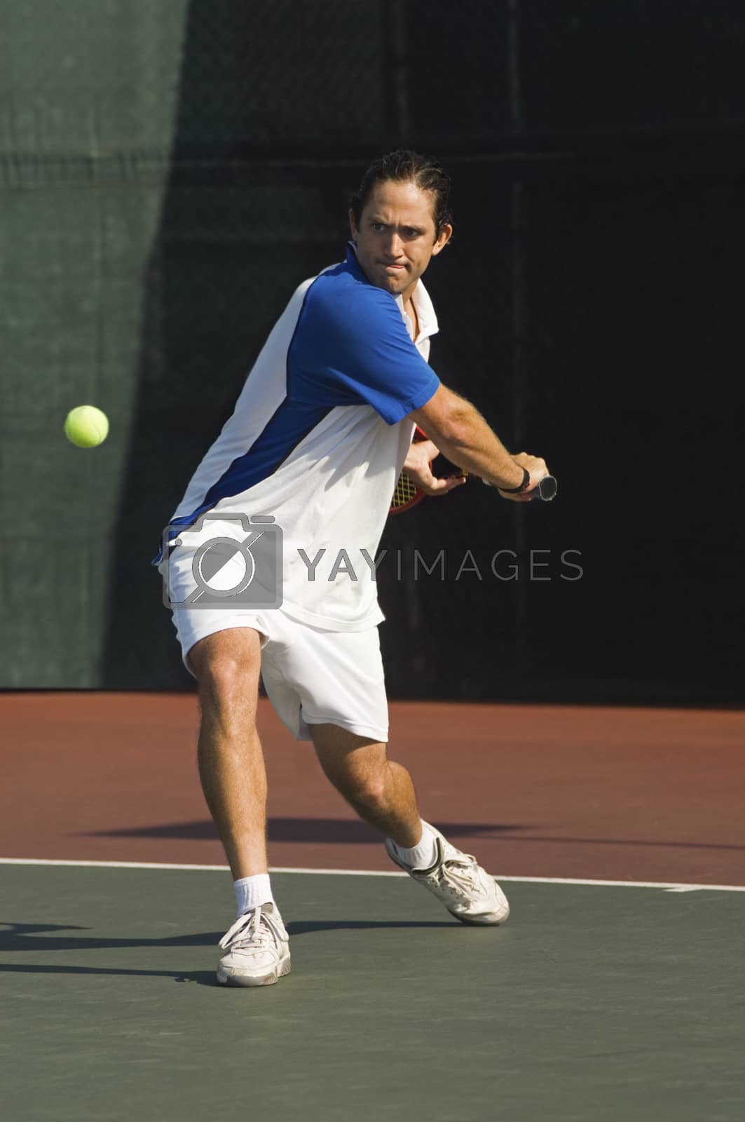 Royalty free image of Full length of male tennis player about to hit a ball by moodboard
