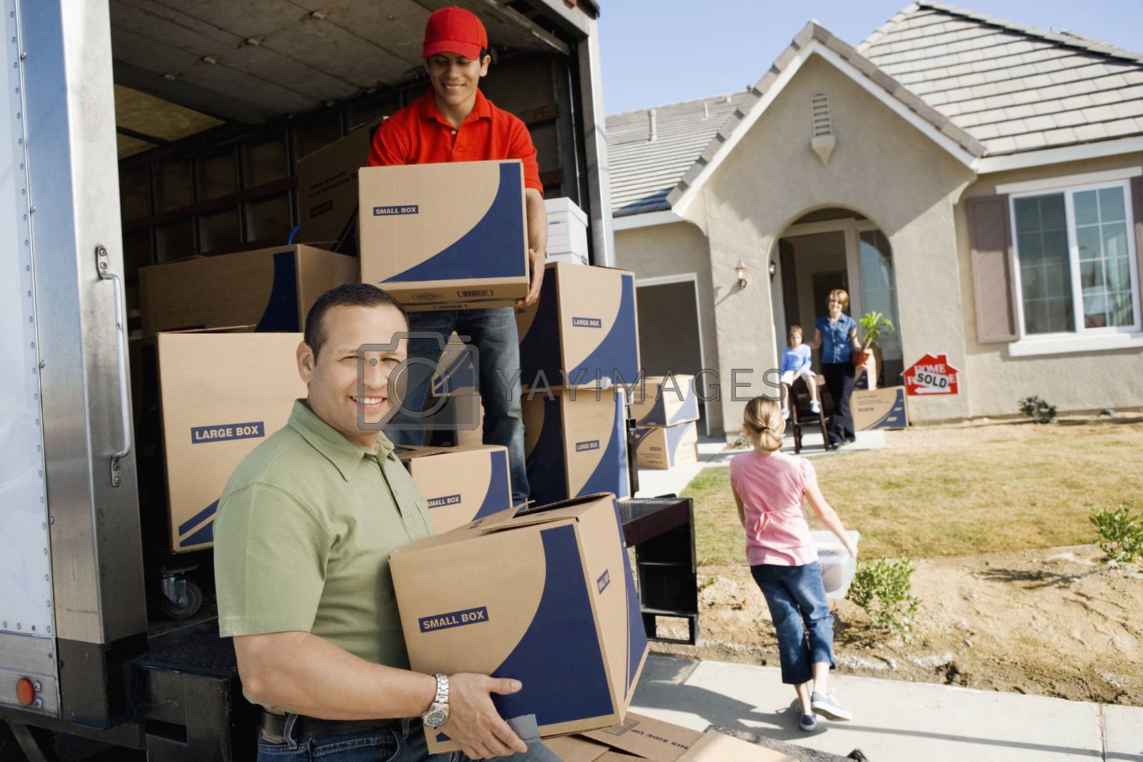 Royalty free image of Family unloading removal van in front of house by moodboard