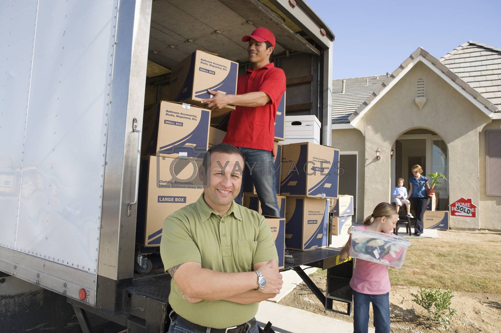 Royalty free image of Family and worker unloading truck of cardboard boxes by moodboard