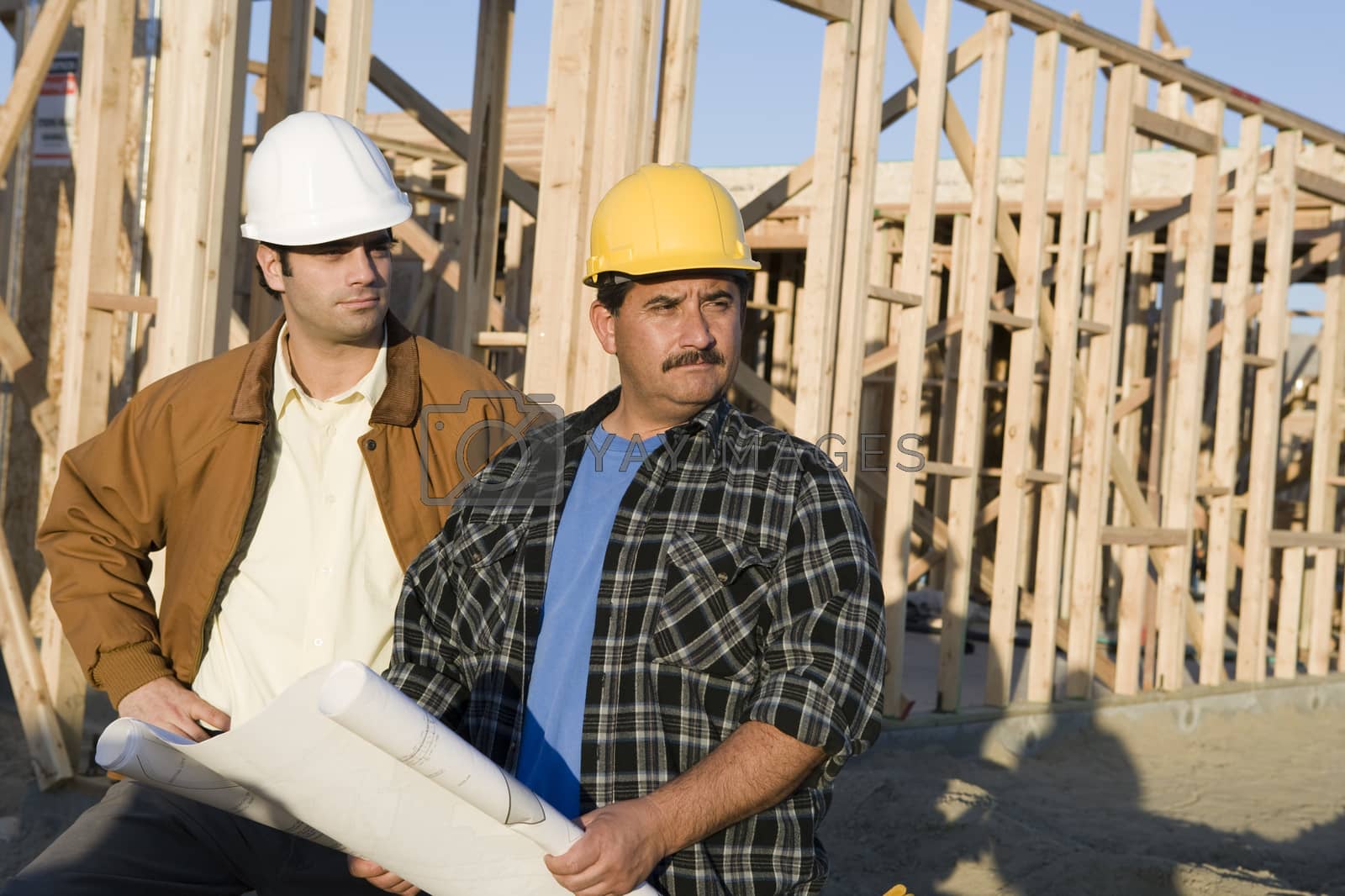 Royalty free image of Two male architects with blueprint at construction site by moodboard