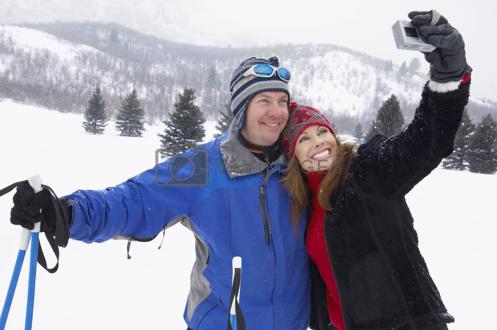 Royalty free image of Happy mature couple taking self portrait in snow by moodboard