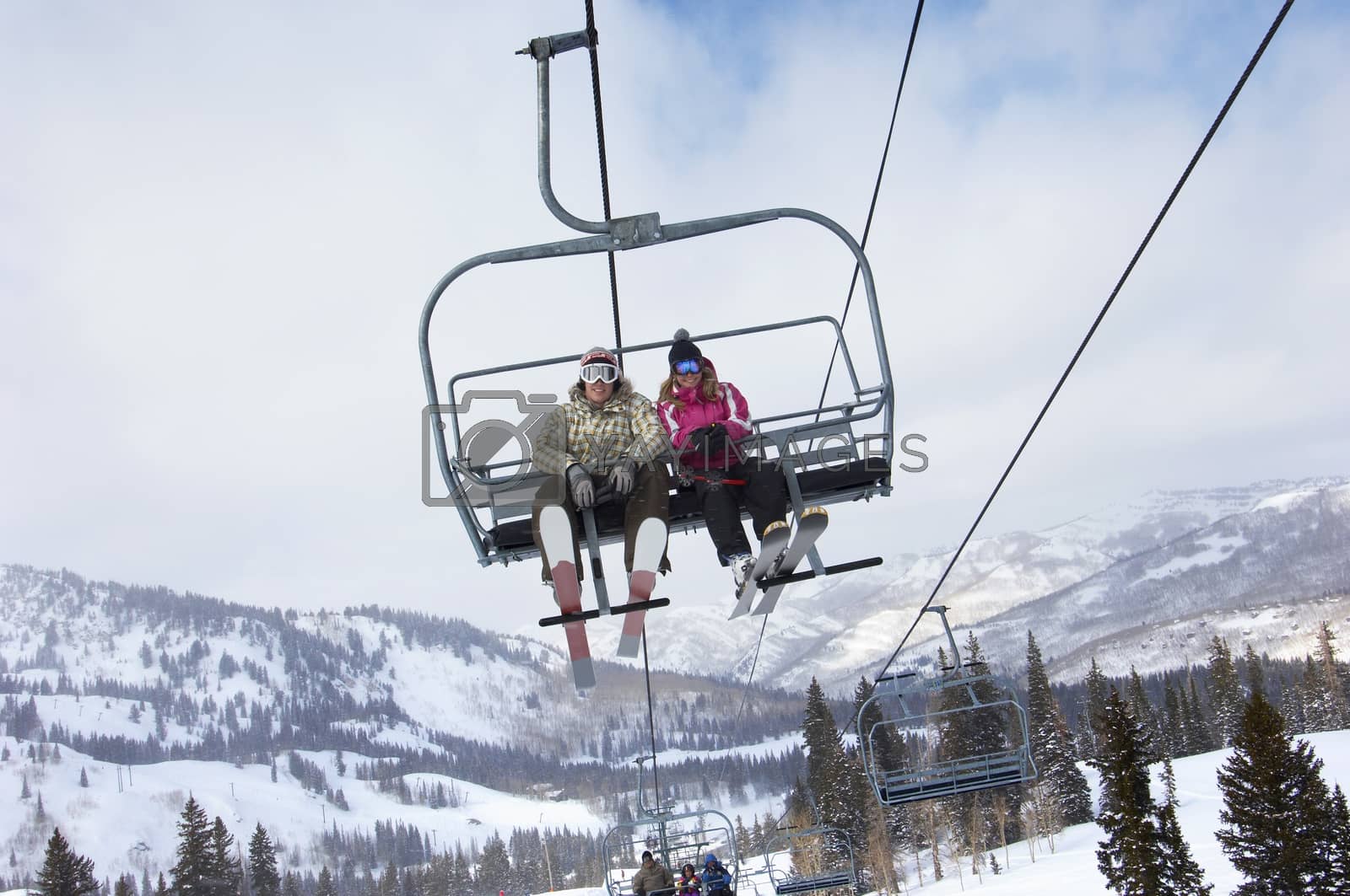 Royalty free image of Low angle view of a couple in skies sitting on ski lift by moodboard