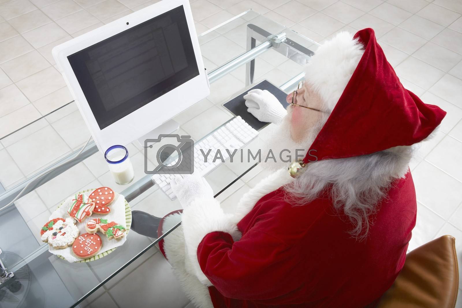 Royalty free image of High angle view of Santa Claus working on computer by moodboard
