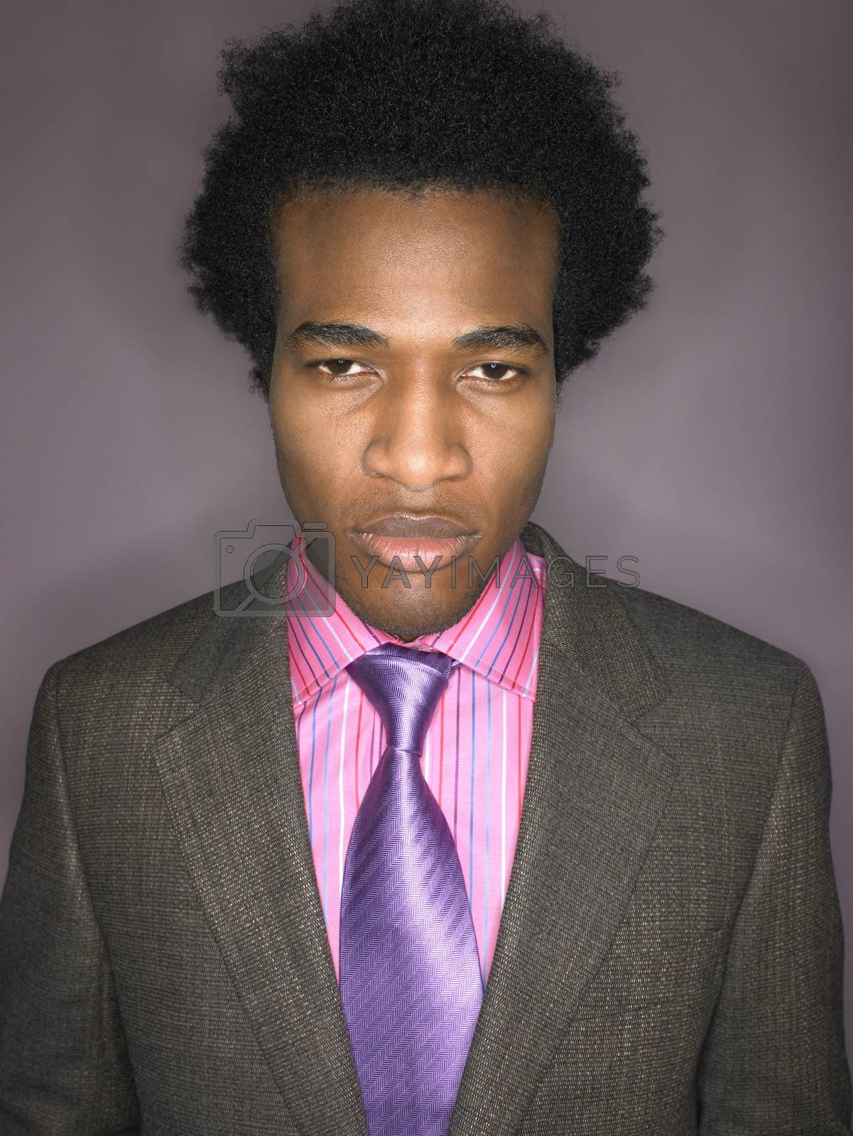 Royalty free image of Portrait of a displeased afro businessman against purple background by moodboard