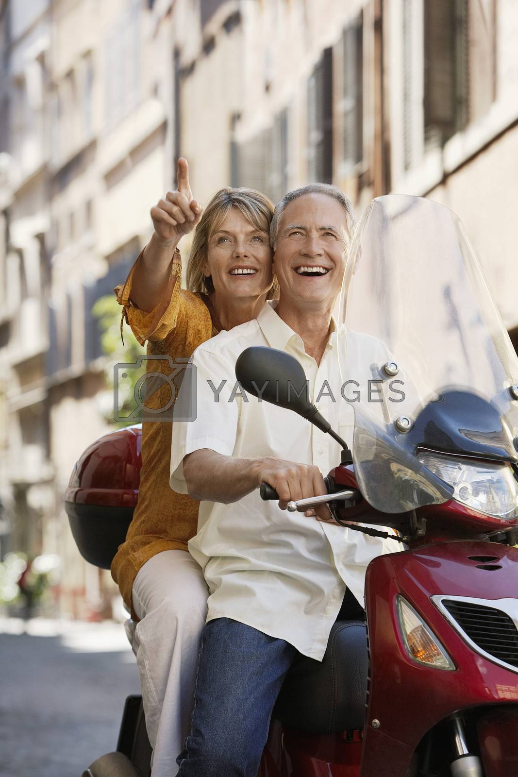 Royalty free image of Middle-aged couple sightseeing on scooter in Rome Italy by moodboard