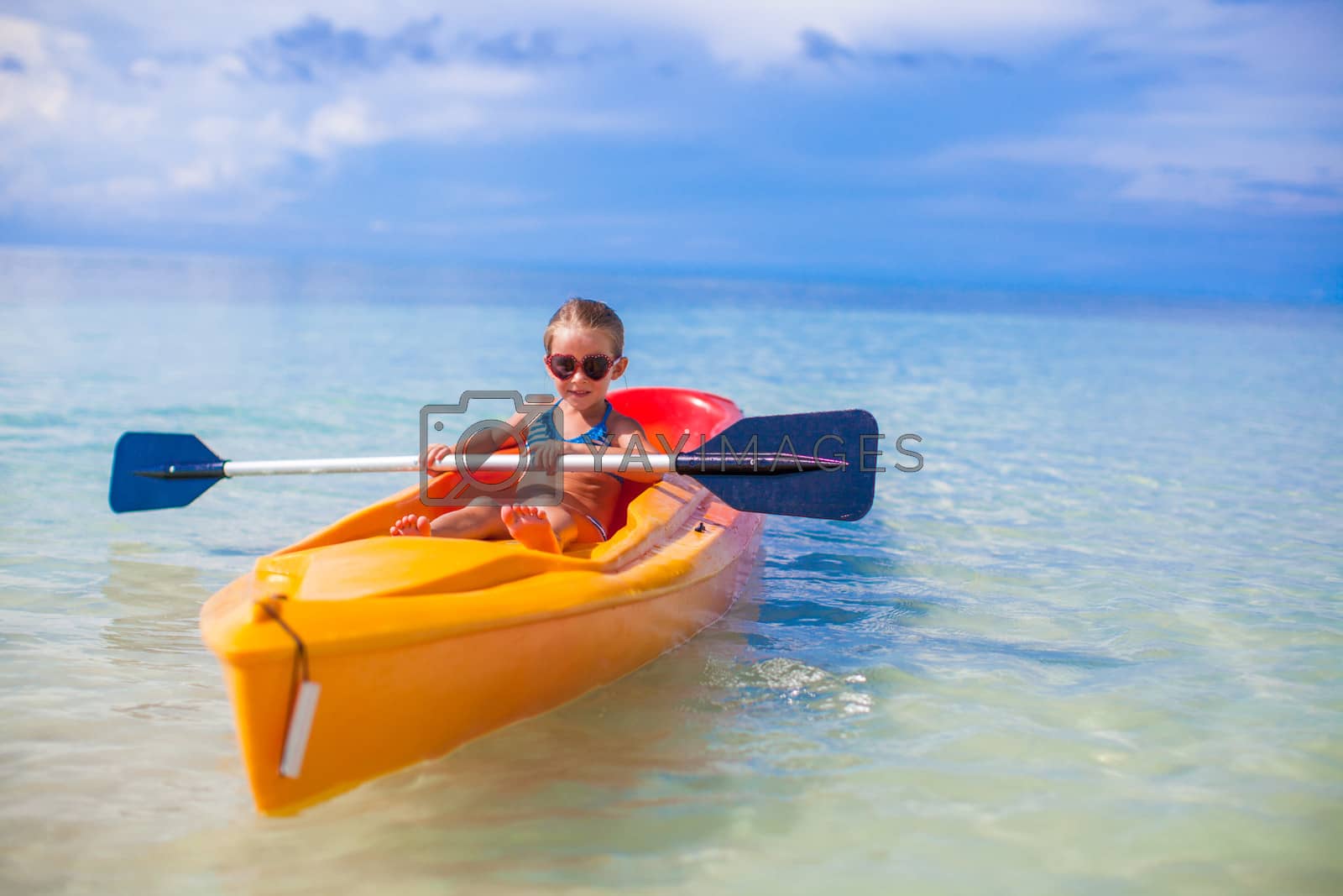 Royalty free image of Little adorable girl kayaking in the clear blue sea by travnikovstudio