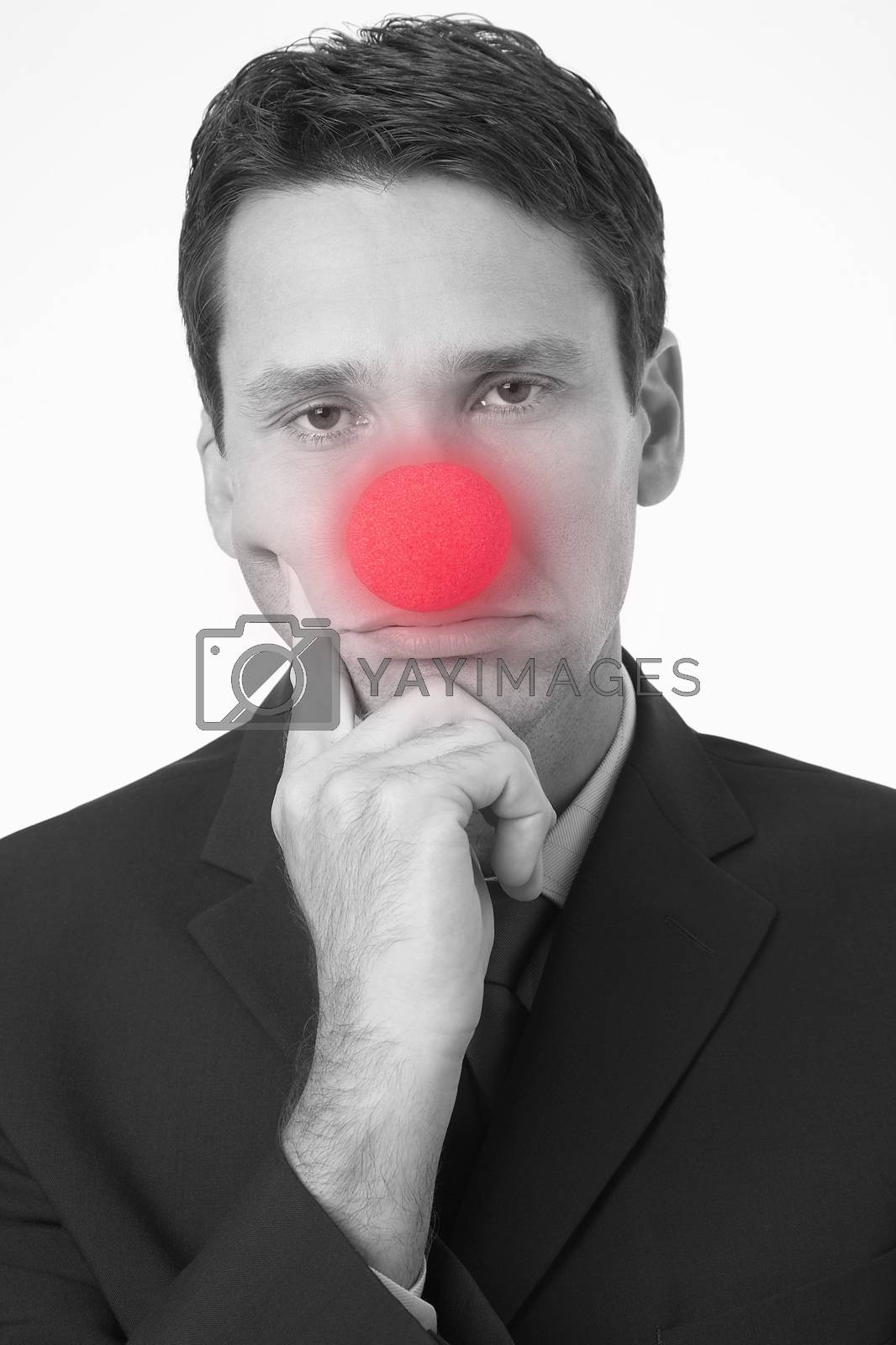 Royalty free image of Portrait of a sad businessman wearing clown nose on white background by moodboard