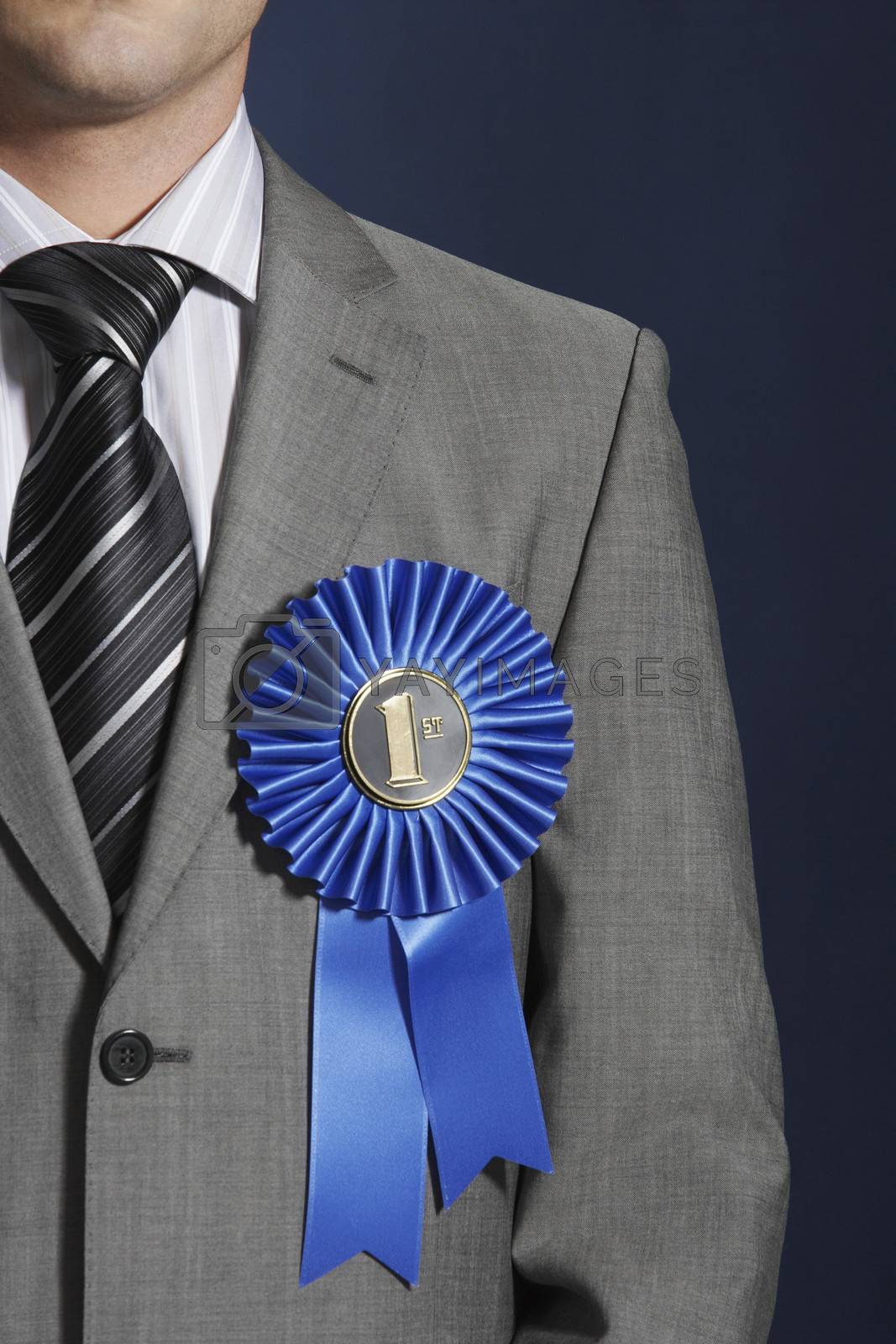 Royalty free image of Closeup midsection of a businessman wearing blue ribbon on lapel against dark background mid section by moodboard