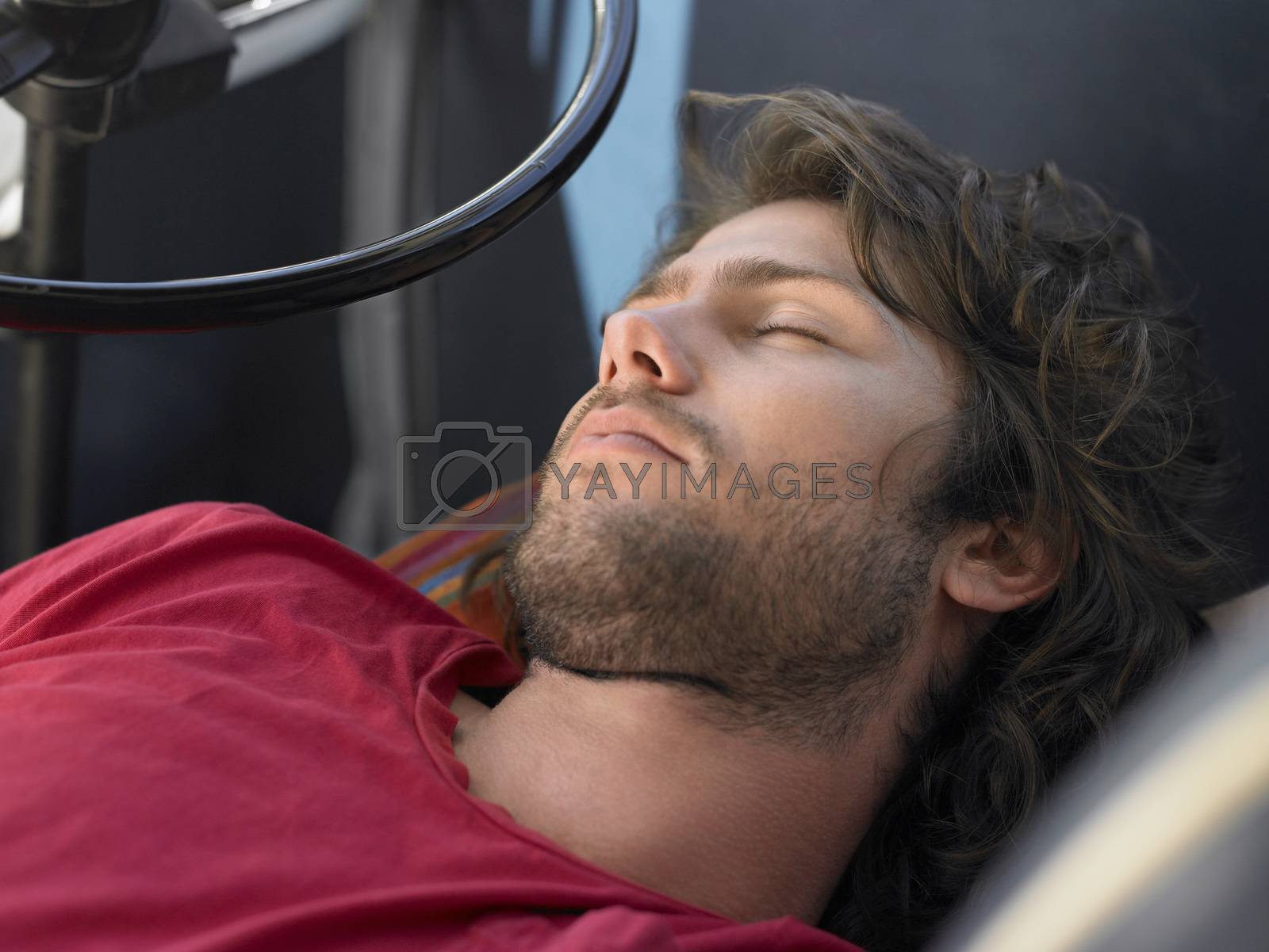 Royalty free image of Young Man Sleeping in Vehicle head and shoulders by moodboard