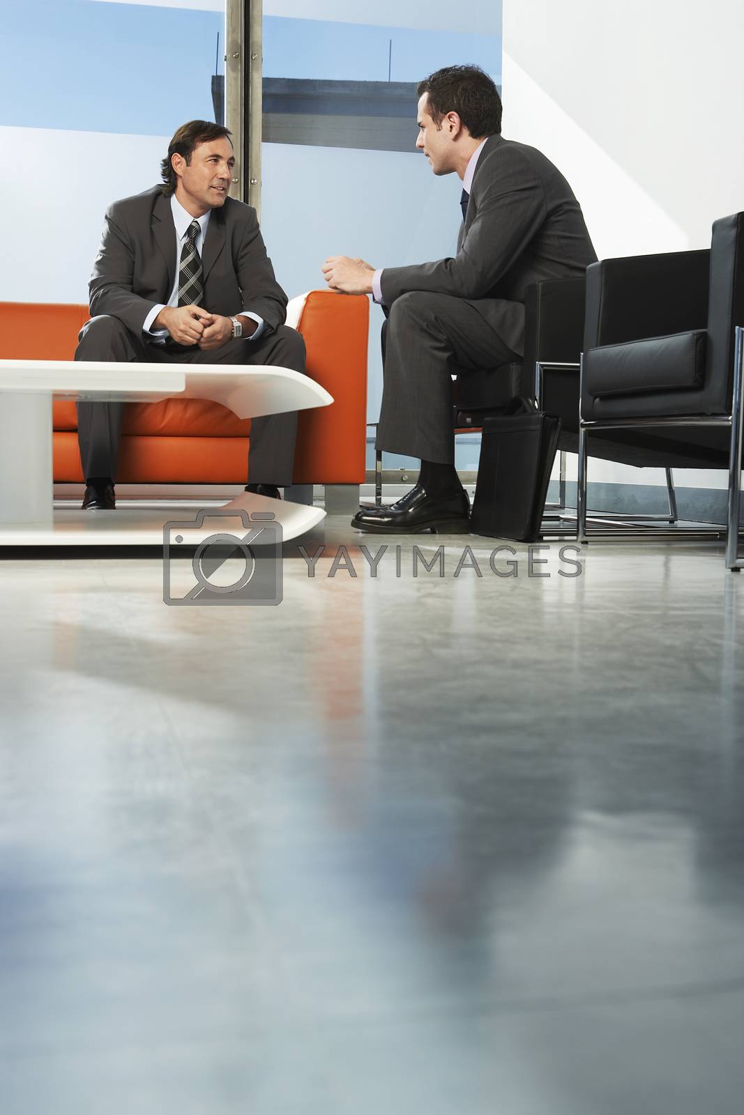 Royalty free image of Two businessmen having meeting in office lobby by moodboard