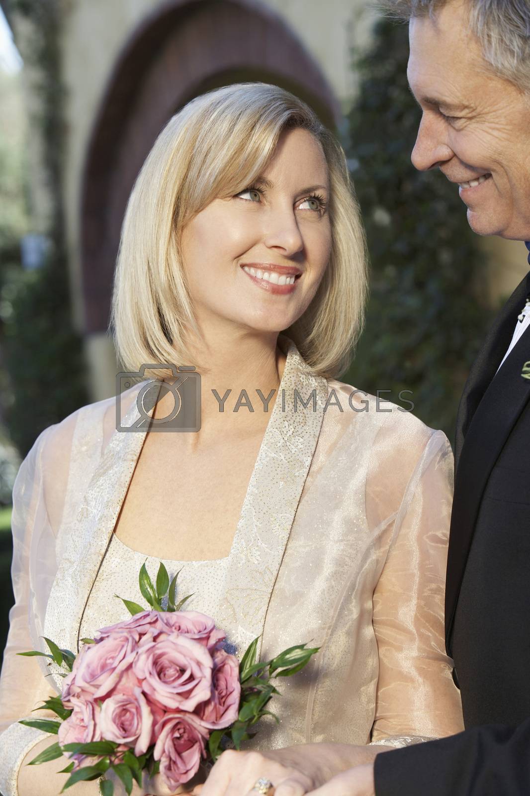 Royalty free image of Happy loving couple in formal wear looking at each other by moodboard