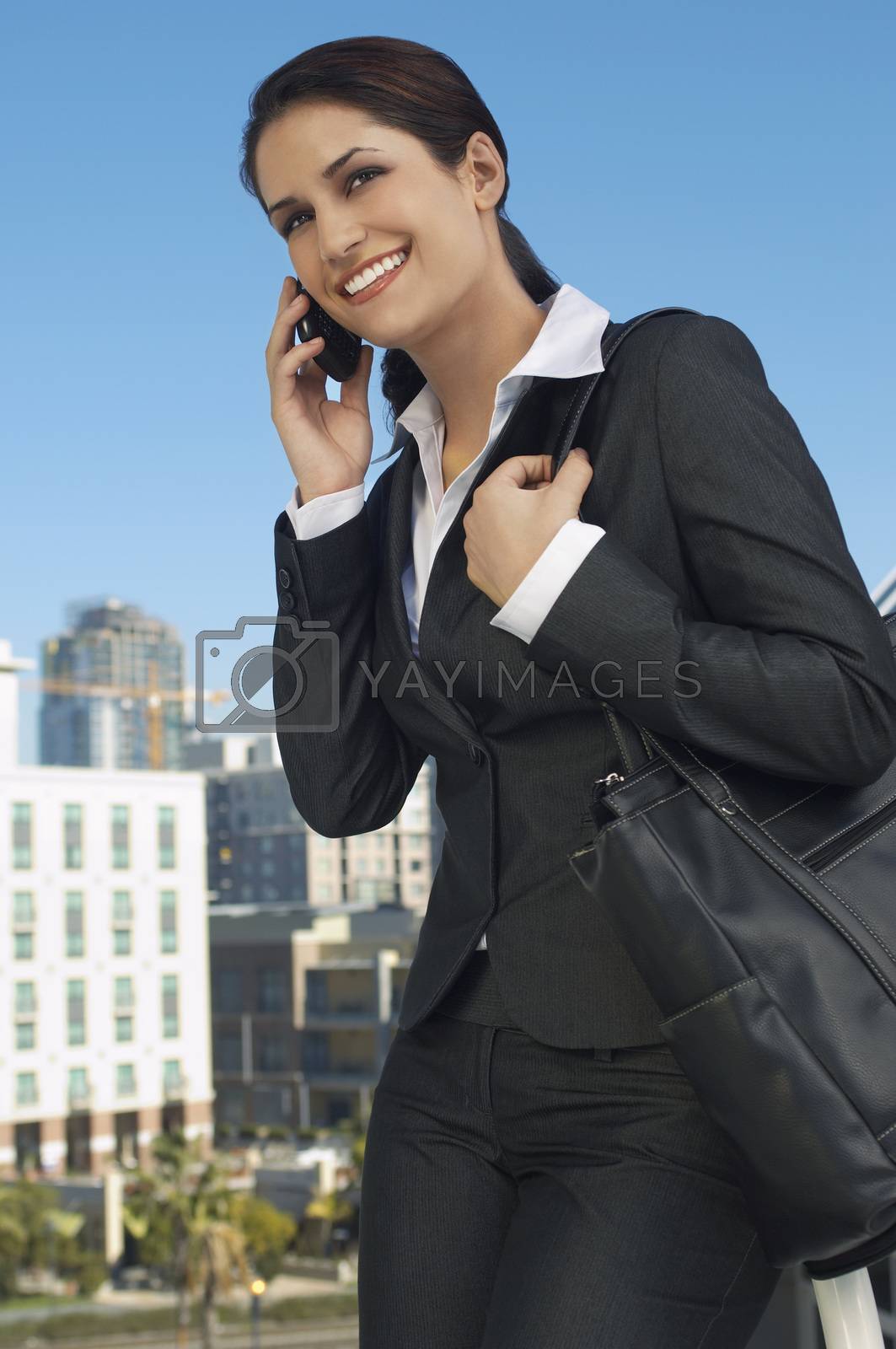 Royalty free image of Beautiful businesswoman using cell phone outdoors by moodboard