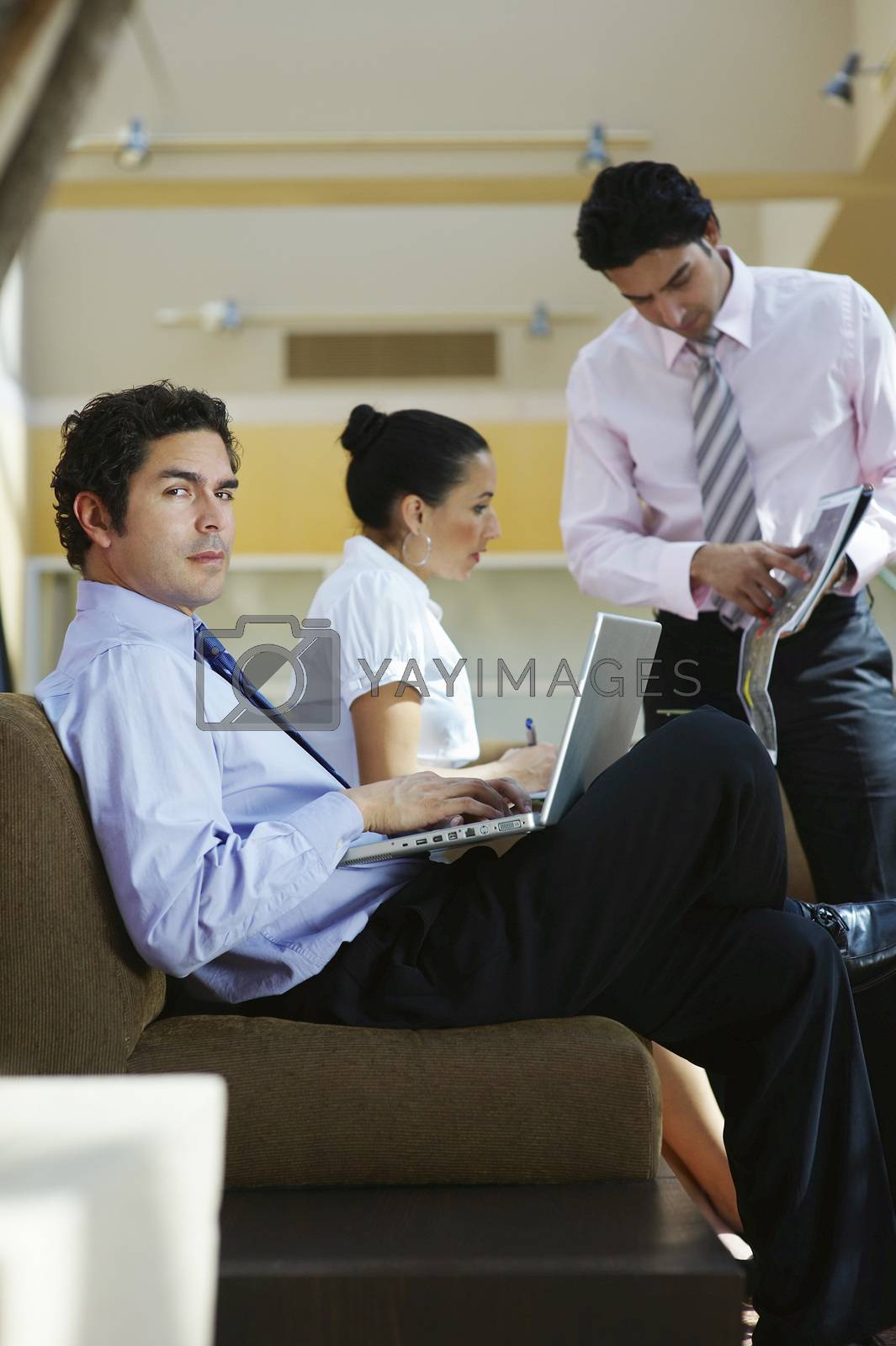 Royalty free image of Young business people working in office by moodboard