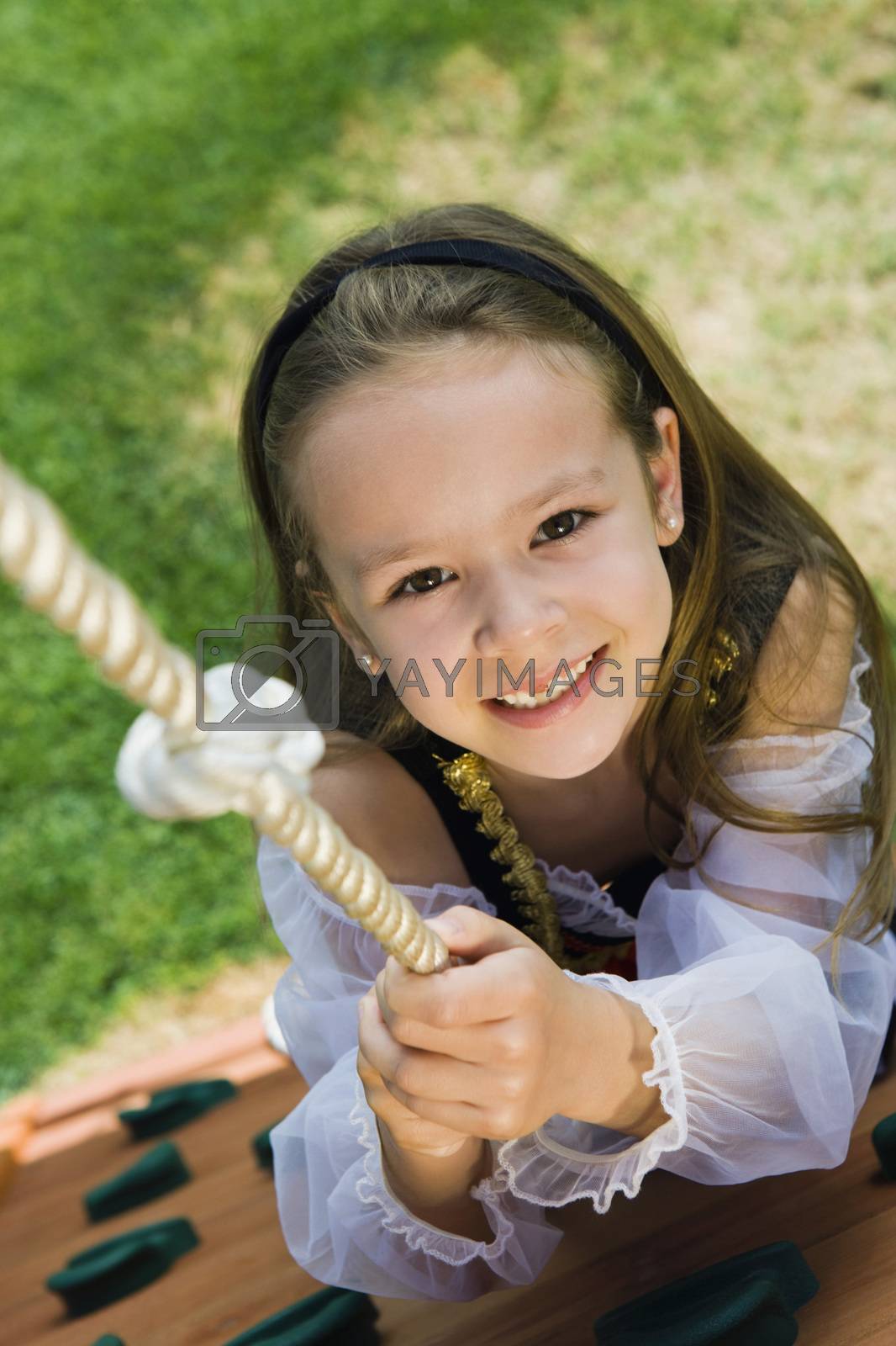 Royalty free image of Dressed up Little Girl Climbing a Rope by moodboard