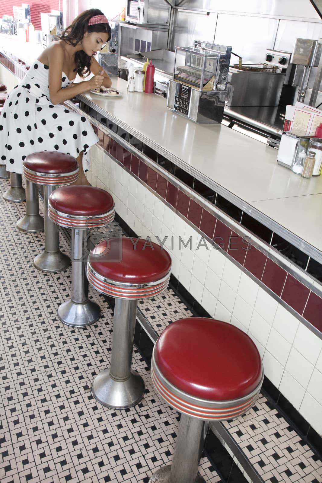 Royalty free image of Young Woman Sitting at a Diner Counter by moodboard