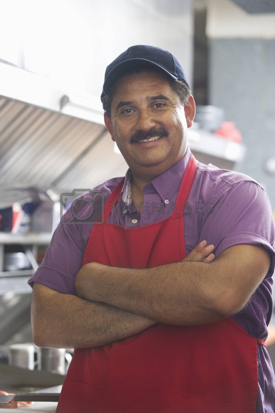 Royalty free image of Portrait of Hispanic Latin confident man standing with arms crossed in restaurant kitchen by moodboard