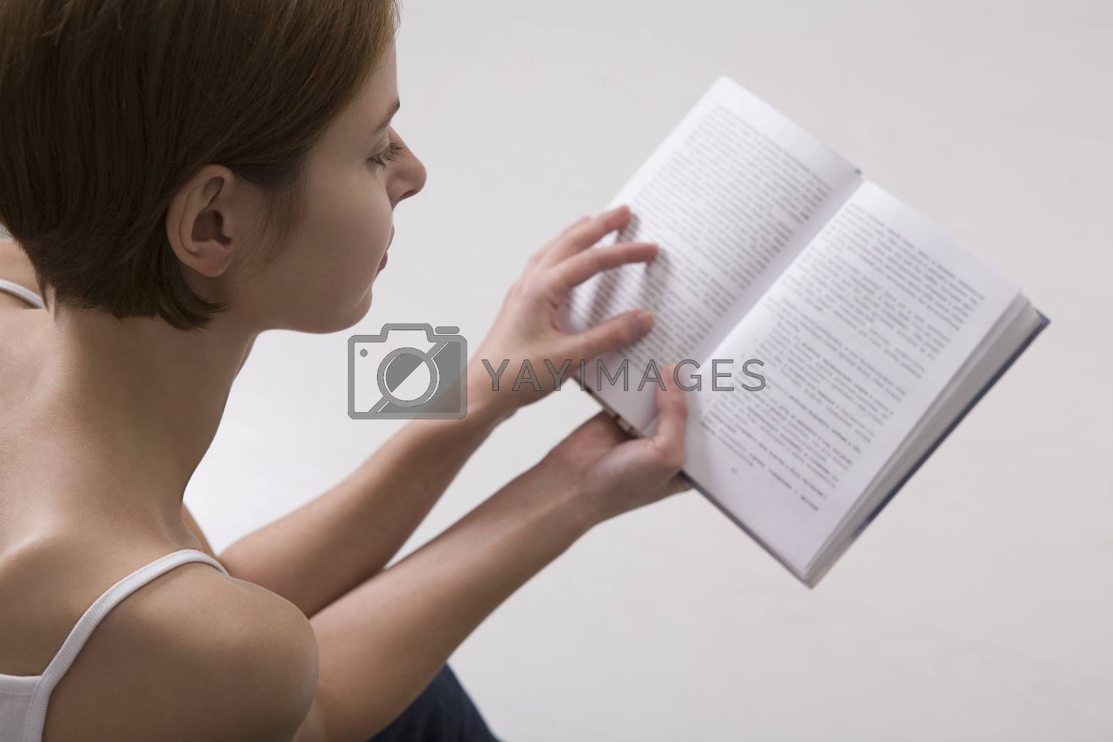 Royalty free image of Young woman reading book by moodboard