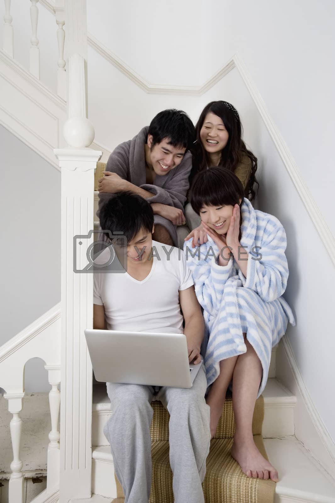 Royalty free image of Young couples enjoying while using laptop by moodboard