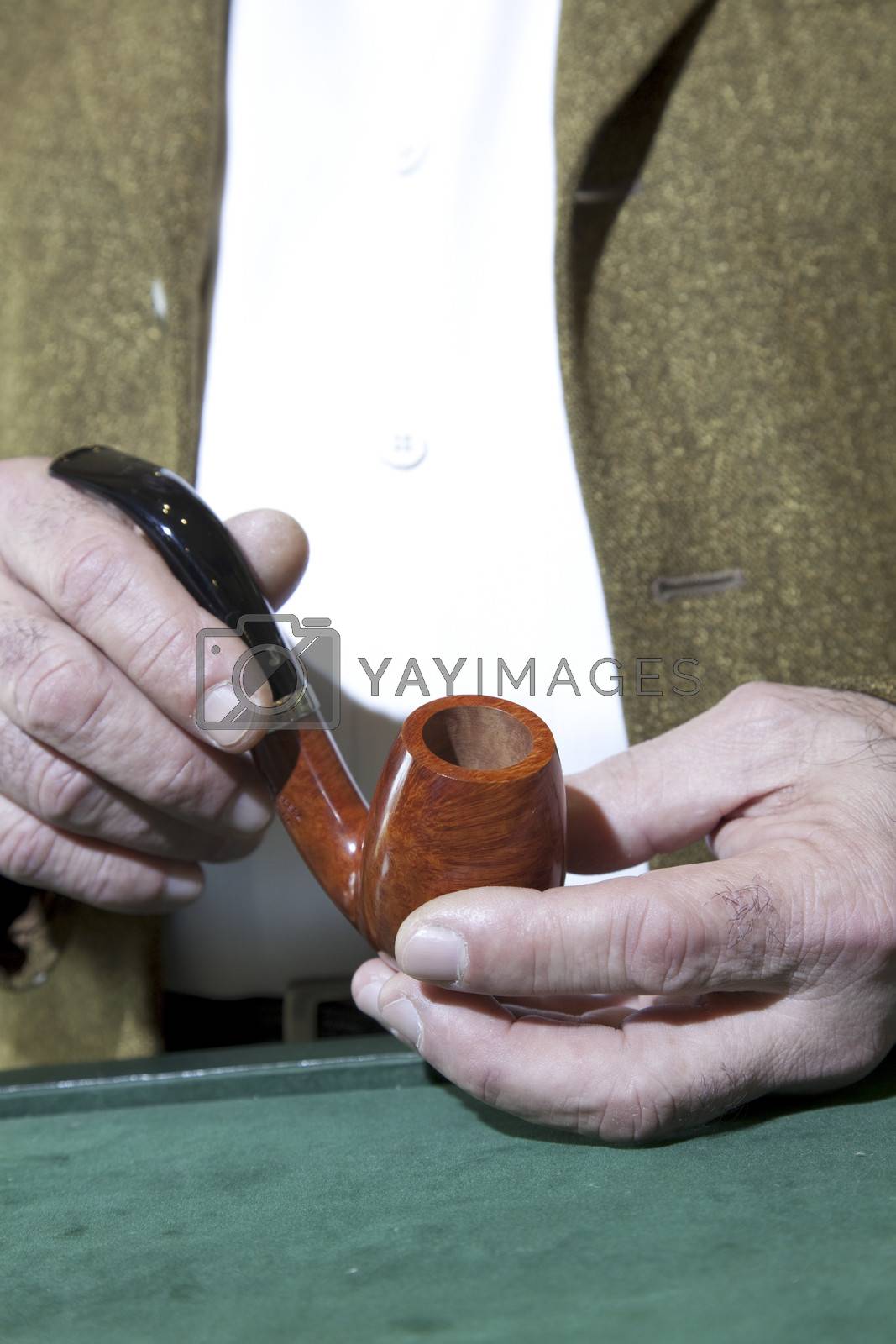 Royalty free image of Close-up view of owner holding tobacco pipe by moodboard